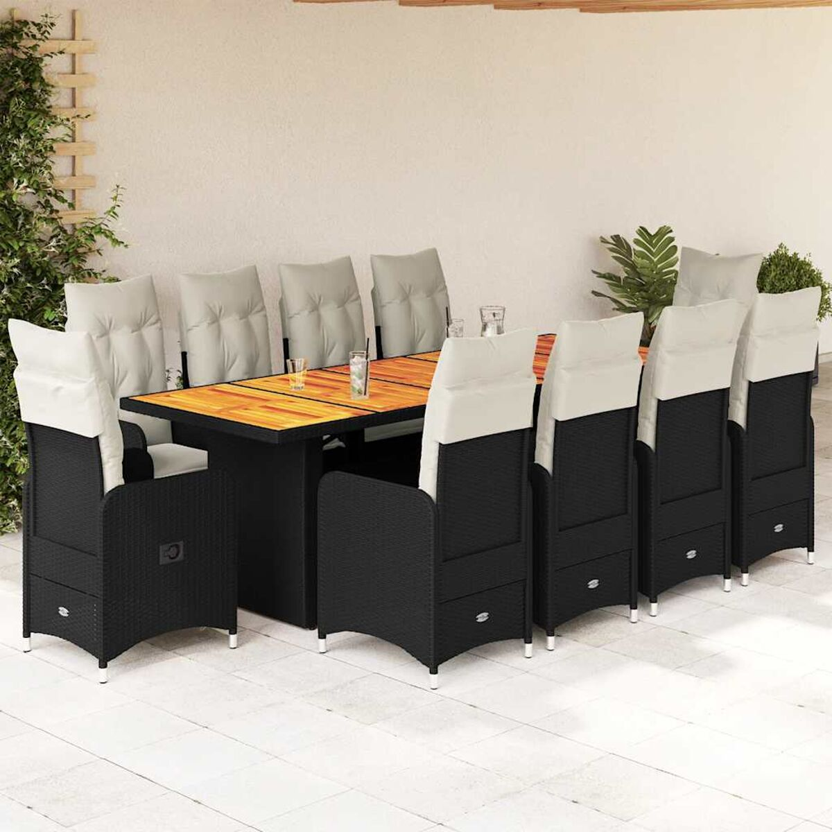 Set da pranzo all'aperto: sedie nere, tavolo in legno, cuscini bianchi e grigi. Parete beige.