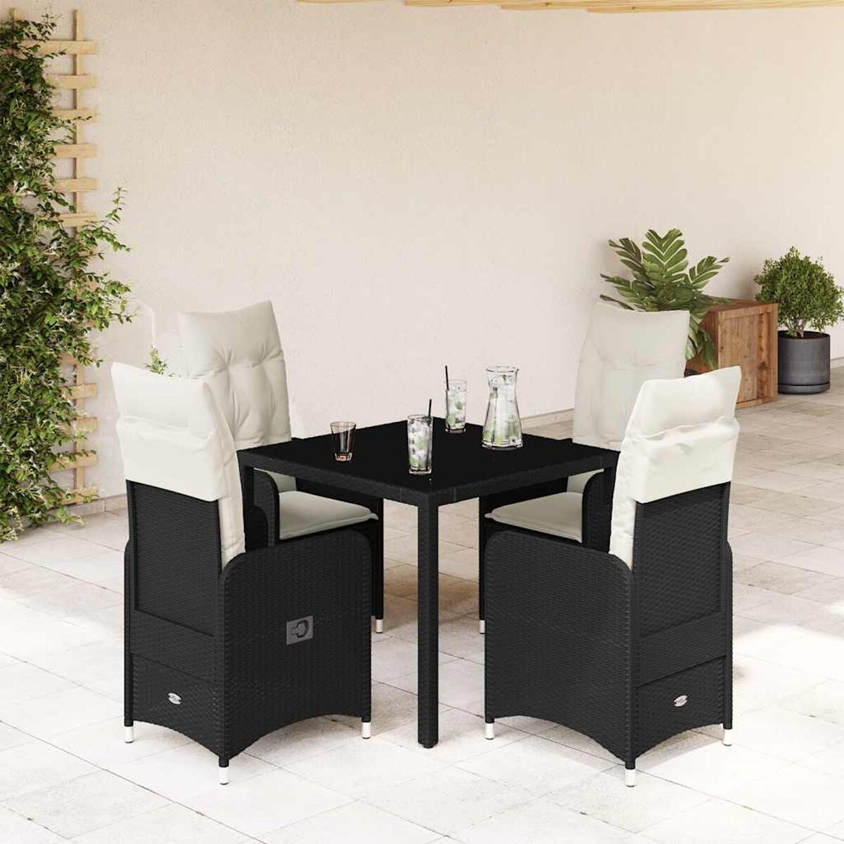 Un set da pranzo esterno in rattan nero con 4 sedie, un tavolo e cuscini bianchi.