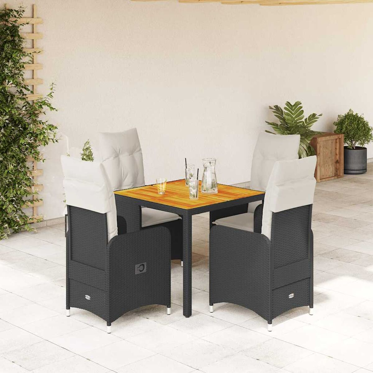 Set da pranzo all'aperto con tavolo in legno e sedie in rattan grigio scuro. Bevande sul tavolo. Parete beige.