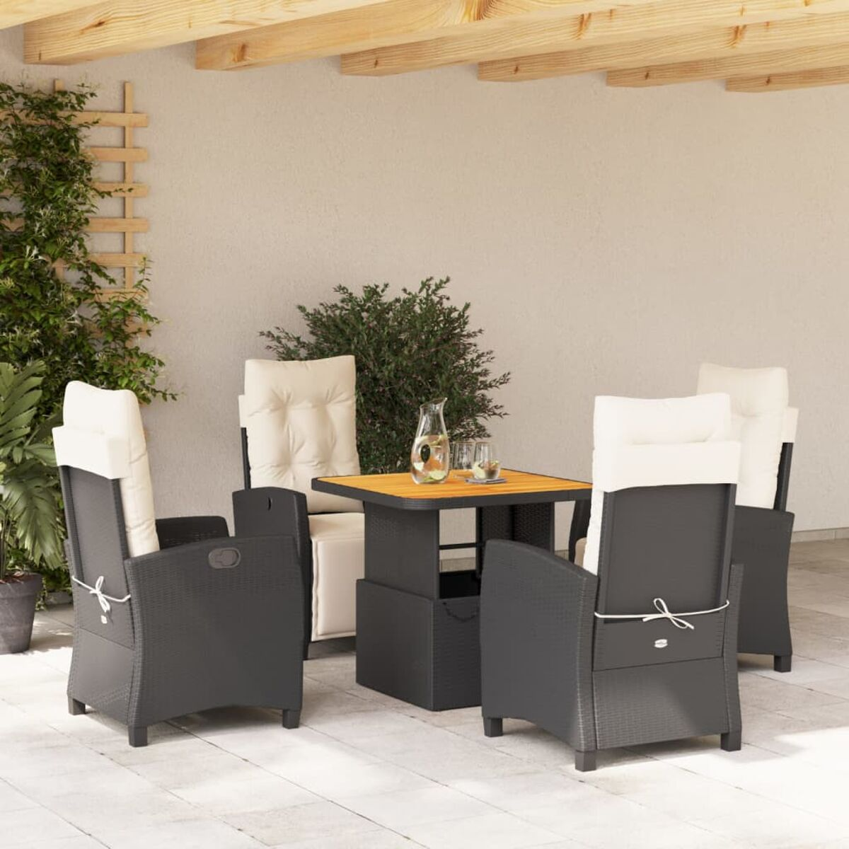 Gartenmöbel mit weißen Kissen und Tisch. Schwarzes Korbgeflecht, graue Kissen. Überdachte Terrasse.
