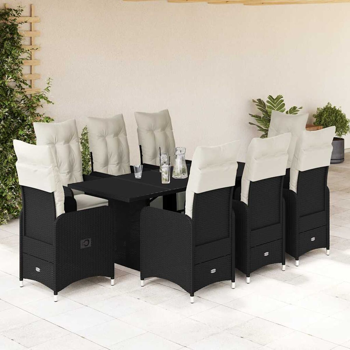 Set da pranzo in vimini nero. Tavolo rettangolare e sedie con cuscini bianchi.