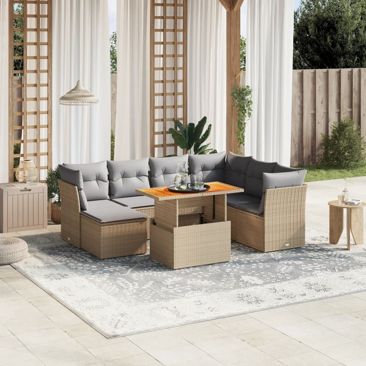Outdoor-Rattansofa mit Tisch, Kissen, Teppich und Dekoration.
