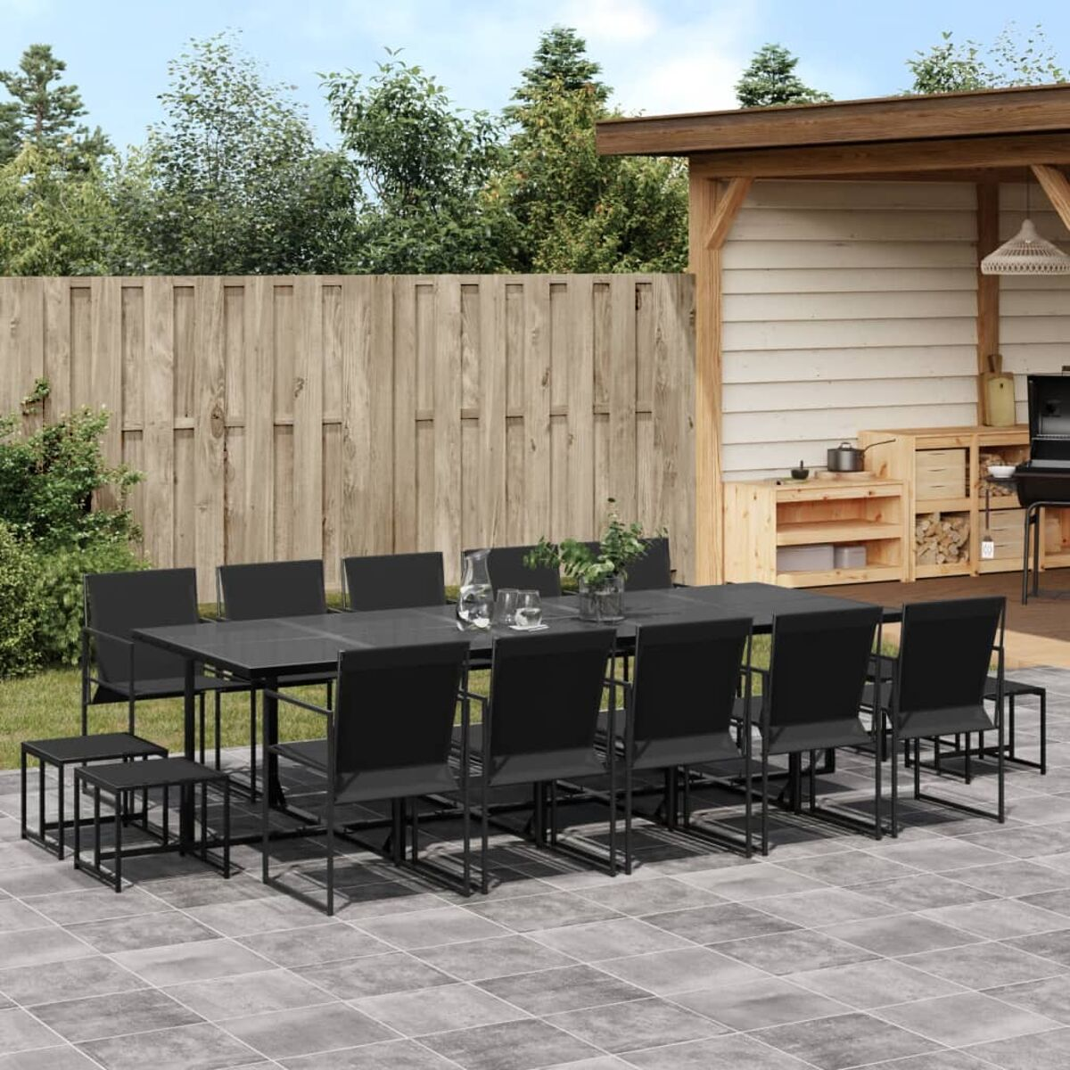 Großes Ess-Set im Freien mit schwarzen Stühlen und einem langen Tisch auf einer Terrasse.