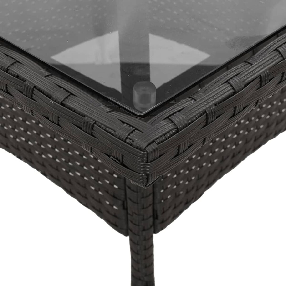 Nahaufnahme einer dunklen grauen Rattan-Tischecke mit Glasplatte.