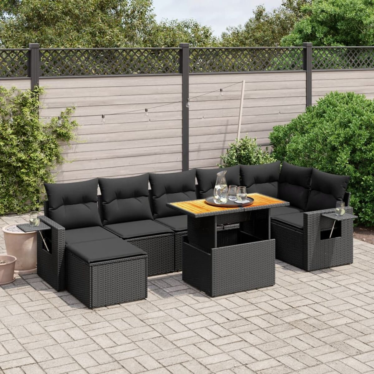 Geflechtmöbel-Set für den Außenbereich, einschließlich Tisch, Sofa und Ottomanen auf einer Terrasse.