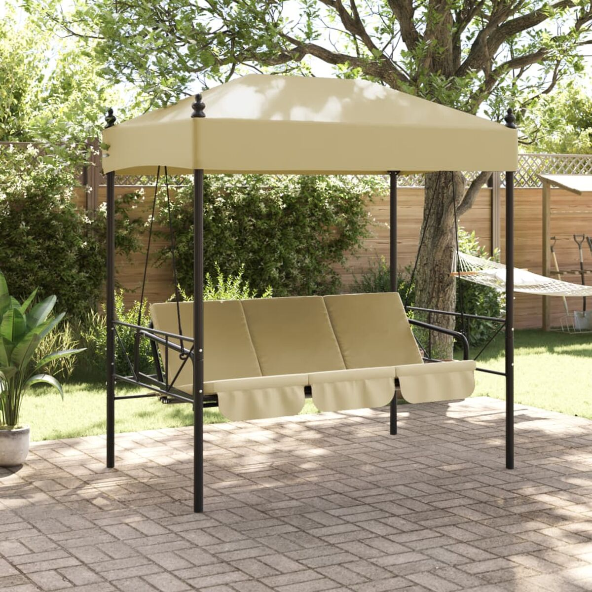 Garten-Schaukel mit beigem Baldachin und Kissen auf einer Ziegelterrasse.