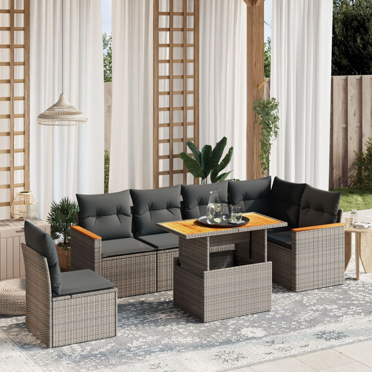 Garnitur für den Außenbereich mit Sofas, einem Tisch und einem Stuhl mit Kissen und Getränken.
