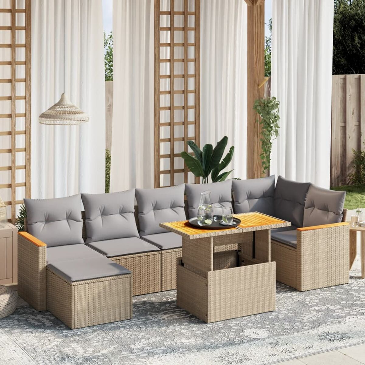 Outdoor-Sitzgruppe mit Kissen, Holzarmlehnen und einem Tisch mit Hubfunktion. Helle, luftige Umgebung.