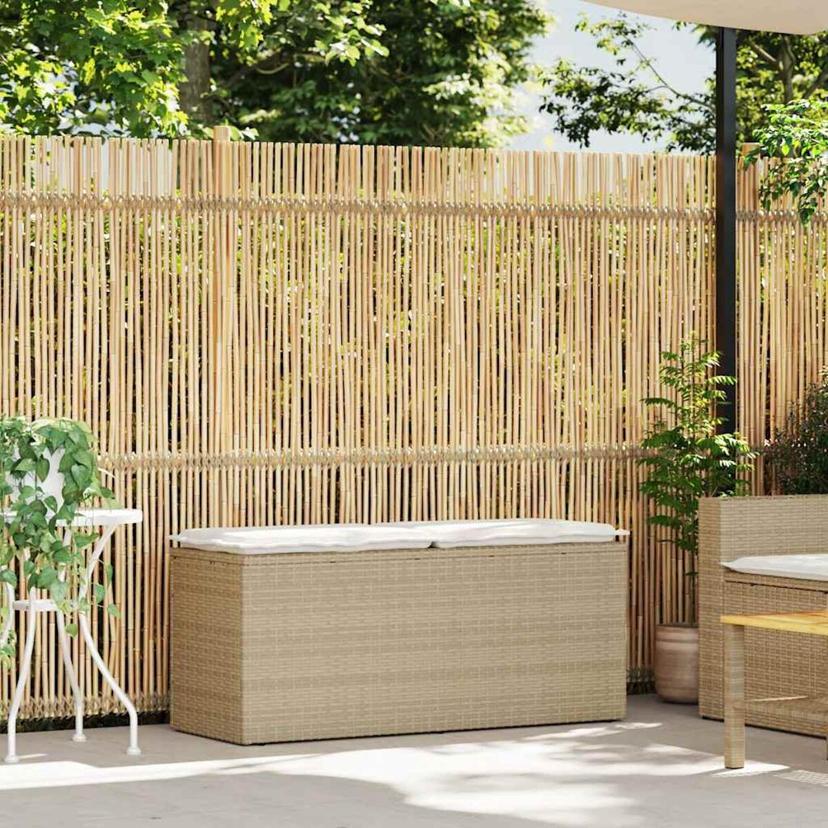 Recinzione in bambù con una panca contenitore in vimini su un patio, in un ambiente soleggiato.