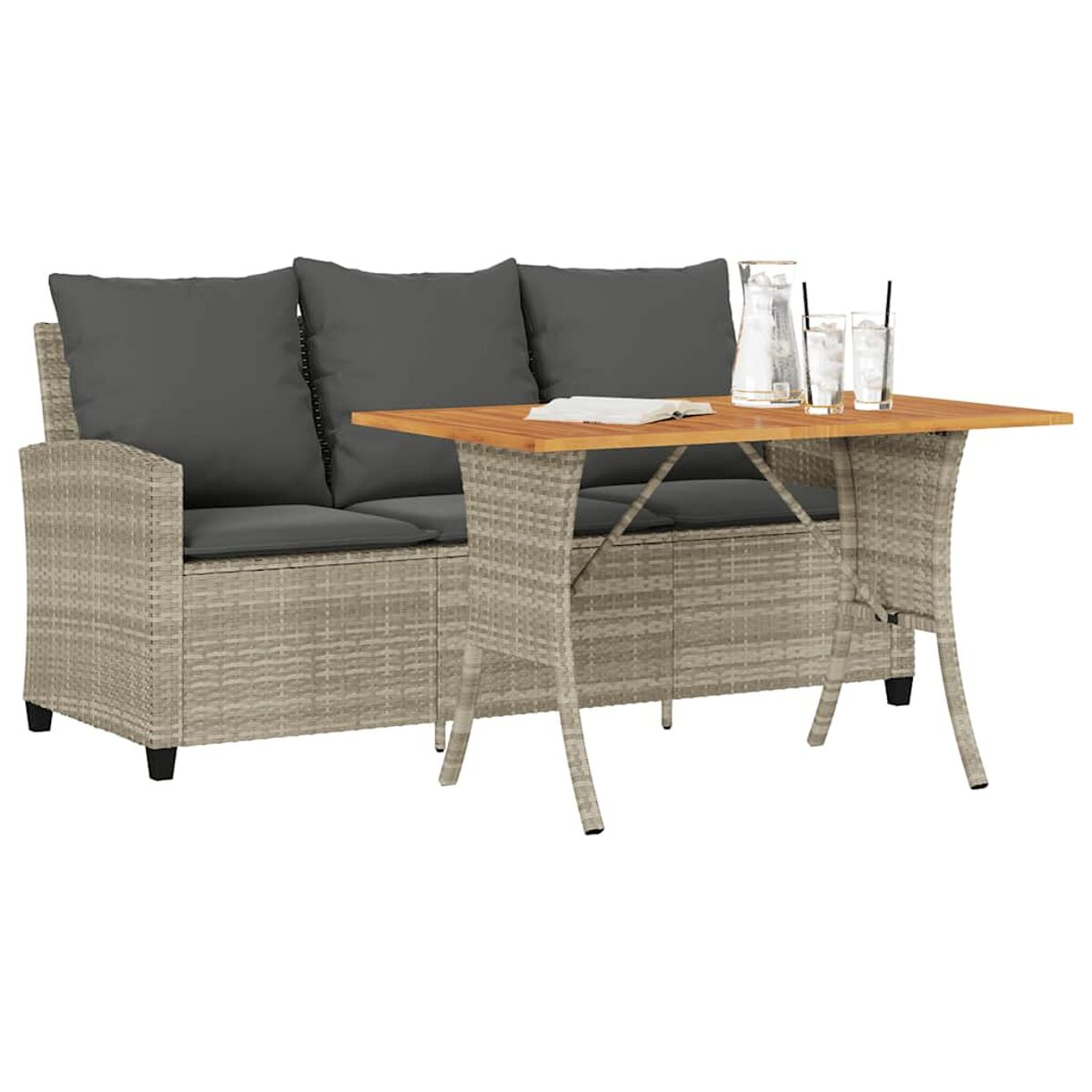 Divano in rattan con cuscini grigi, tavolo in legno con bicchieri e brocca d'acqua sopra.