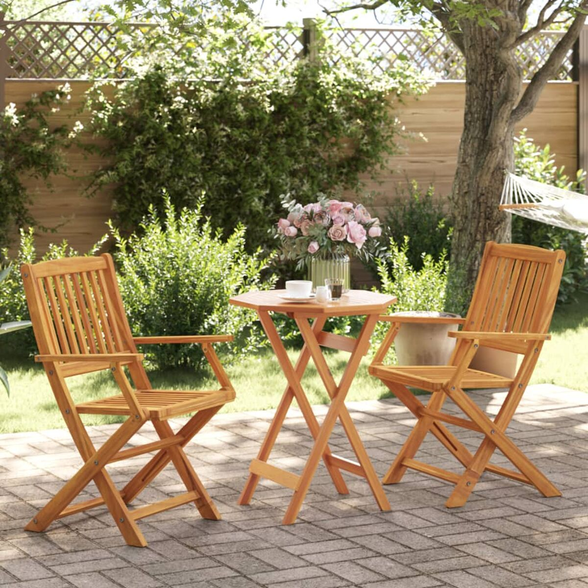 Zwei Holzklappstühle und ein Tisch mit einer Vase Blumen. Szene im Garten.