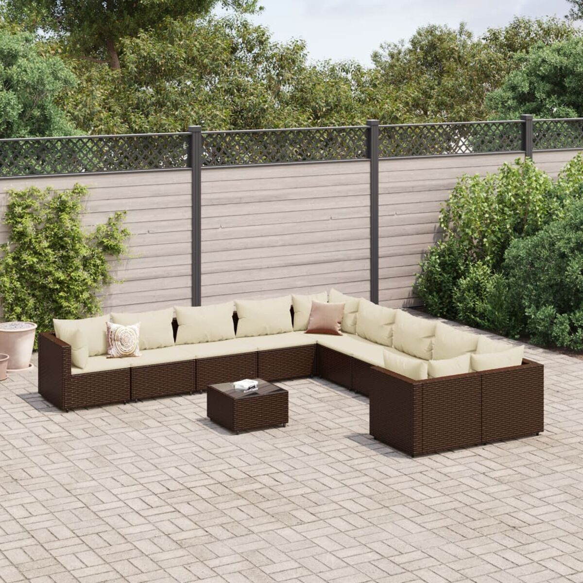 Braunes Rattan-Sofaset im Freien mit beigen Kissen und Tisch.