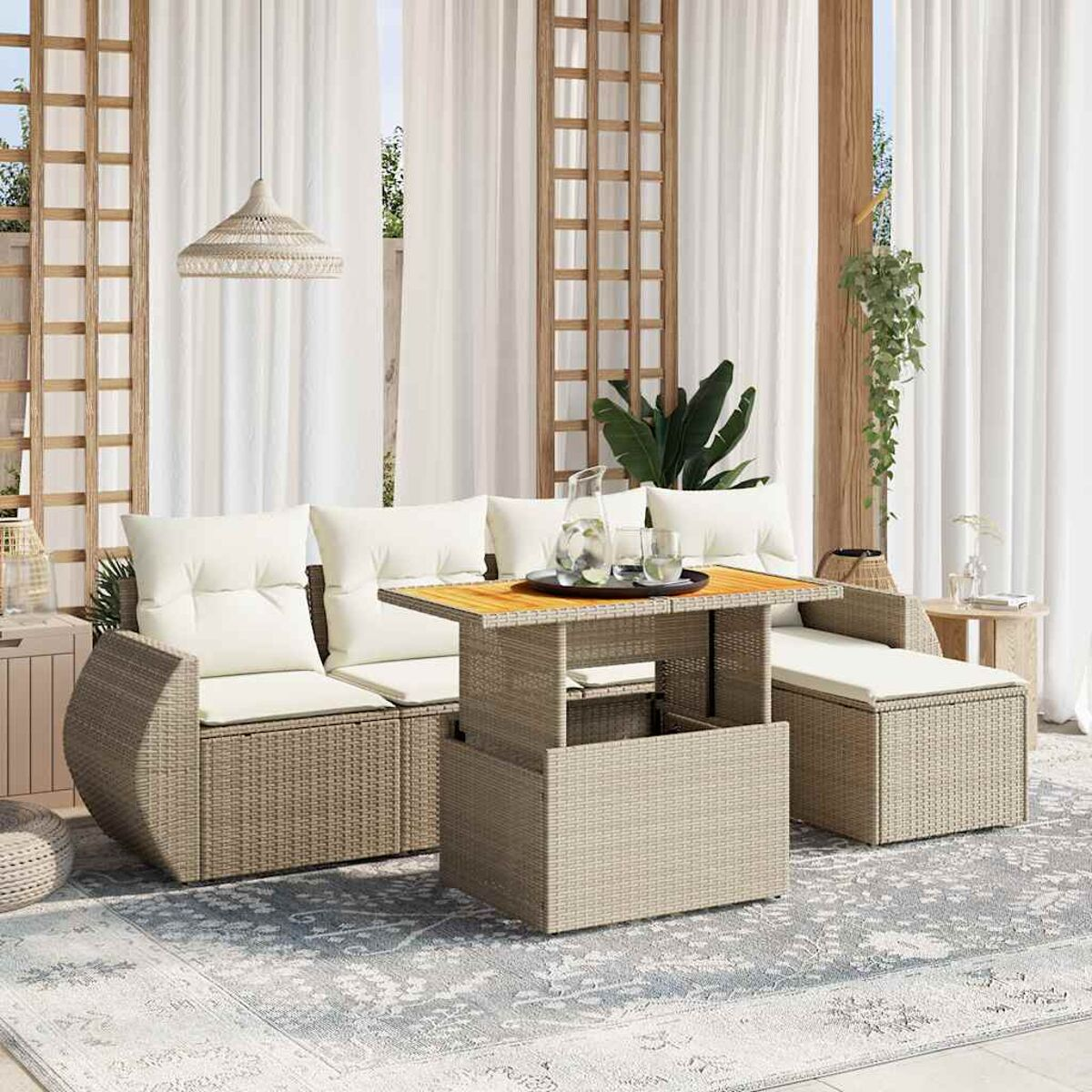 Beige Wicker-Outdoor-Schnitt mit cremefarbenen Kissen und einem Tisch mit Getränken. Weiße Vorhänge im Hintergrund.