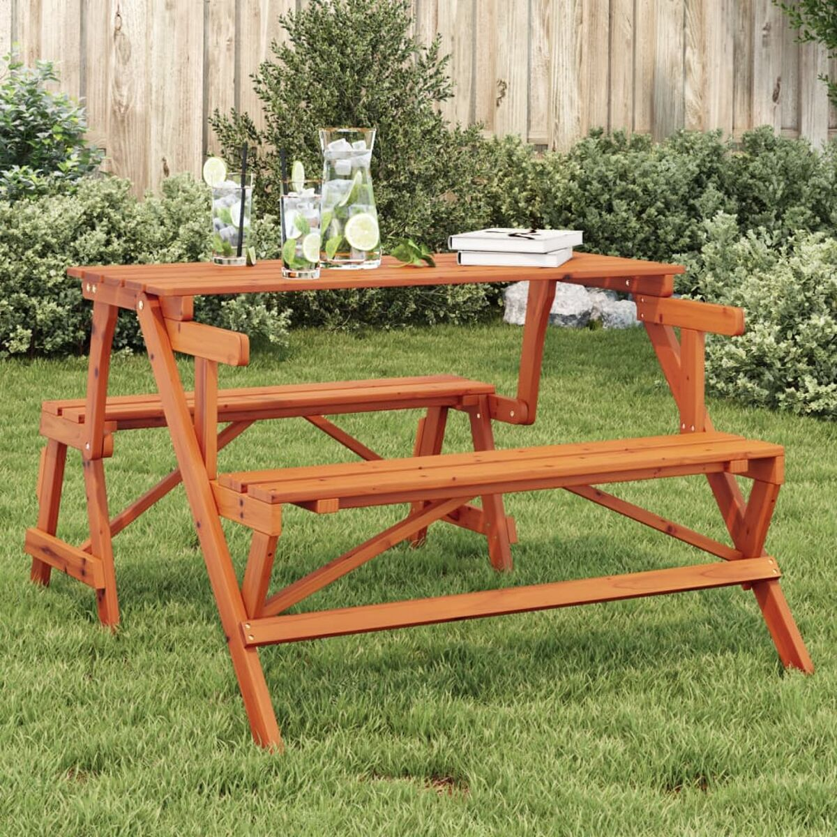 Tavolo da picnic e panche in legno, sull'erba. Bevande sul tavolo.