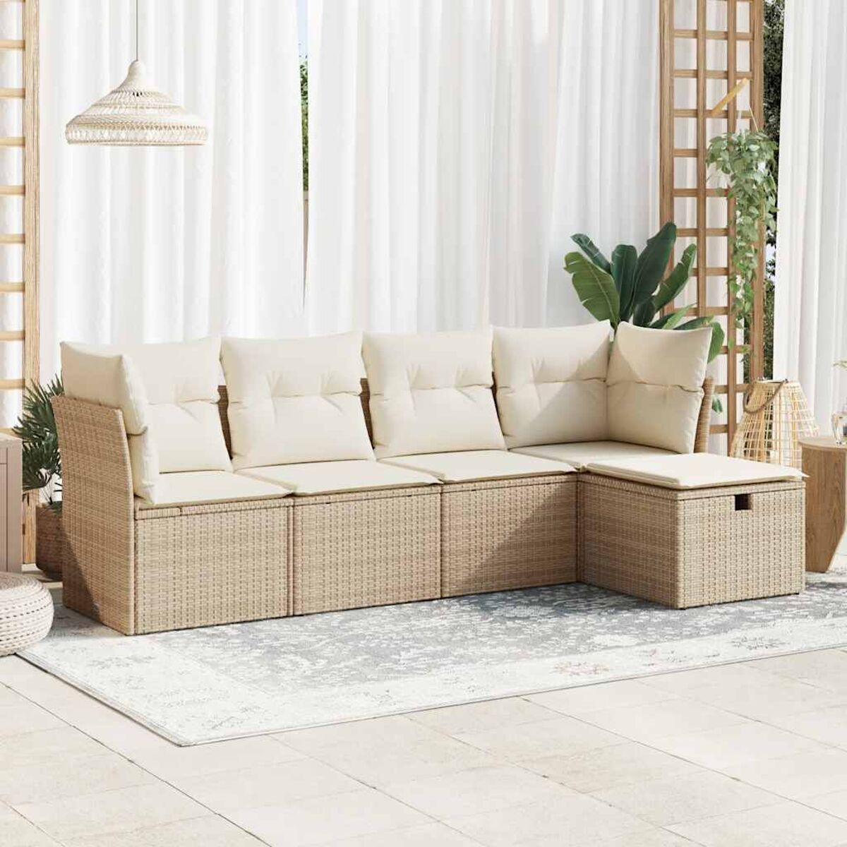 Un divano componibile in rattan beige con cuscini color crema in una stanza luminosa con tende bianche.