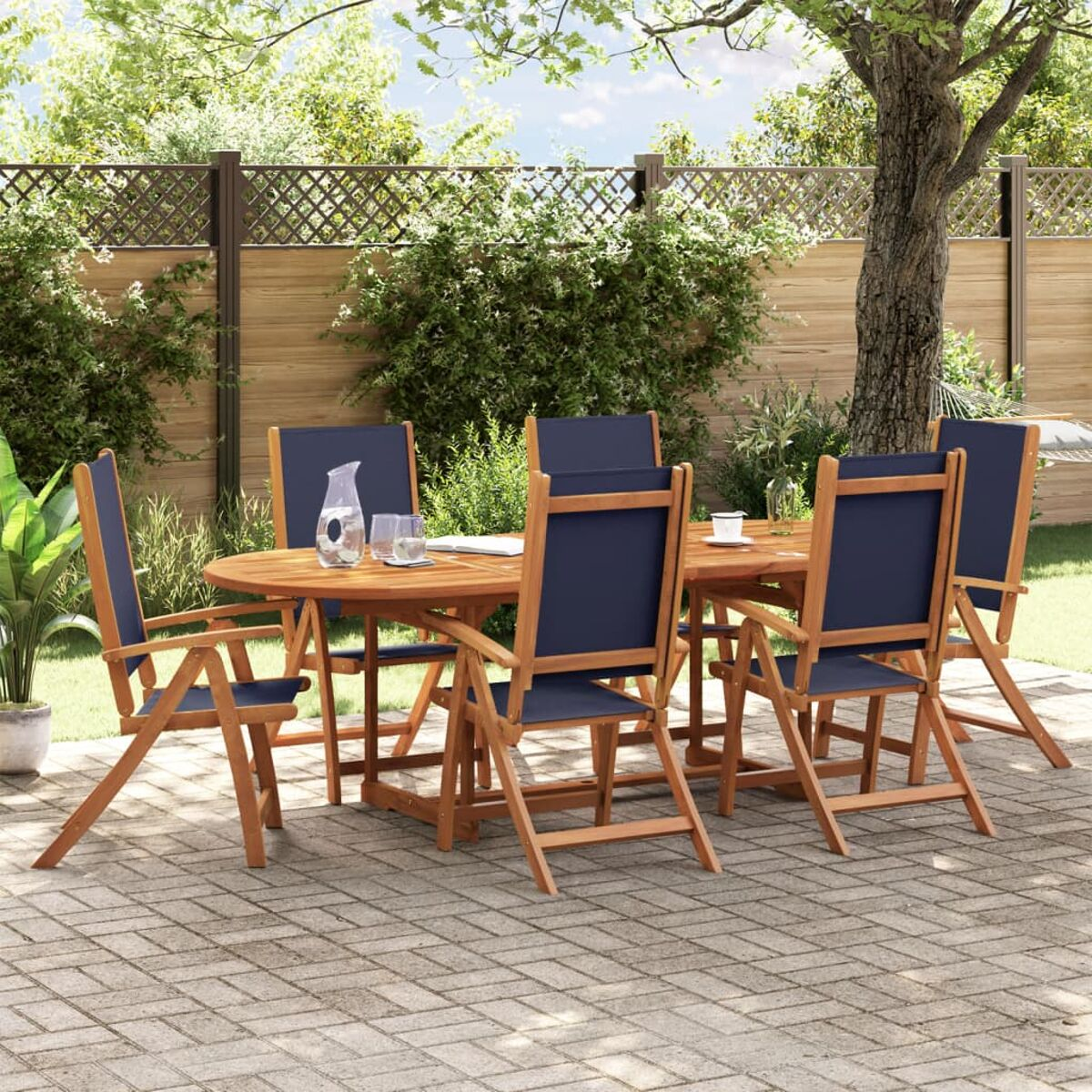 Set da pranzo all'aperto con tavolo in legno, sedie e sedute in tessuto blu. In un giardino.