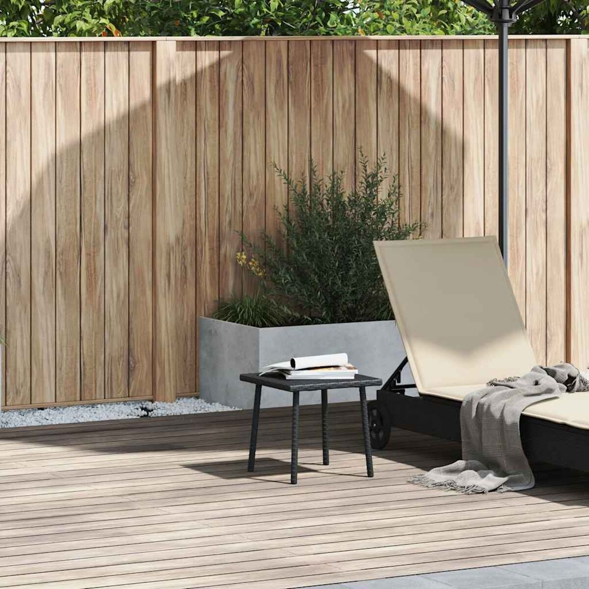 Ein Holzdeck mit Holzzaun, Tisch, Stuhl, Sonnenliege und Pflanzgefäß mit Grün.