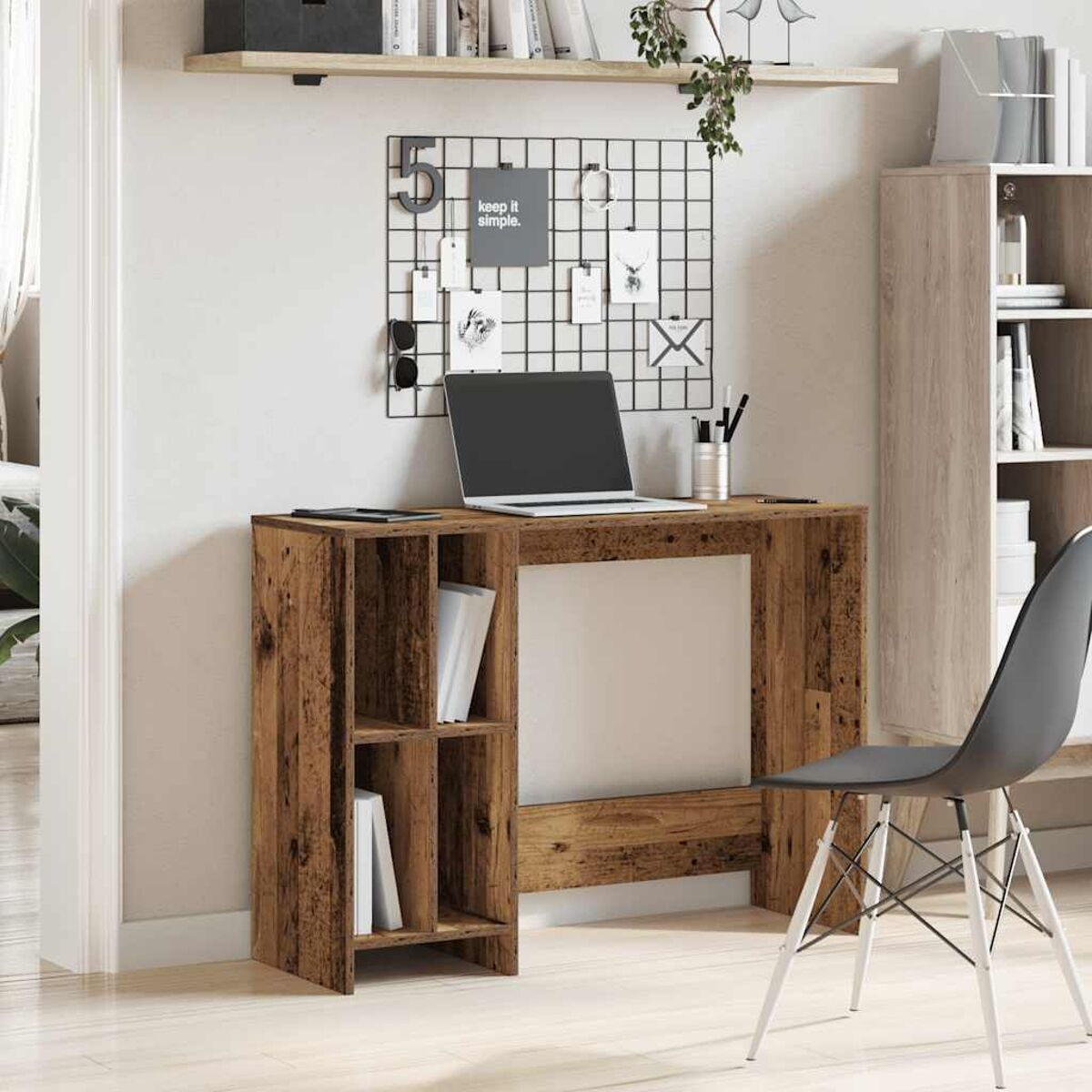 Holzschreibtisch mit Regalen. Laptop oben, schwarzer Stuhl und eine Pinnwand. Wandregal mit Dekoration.