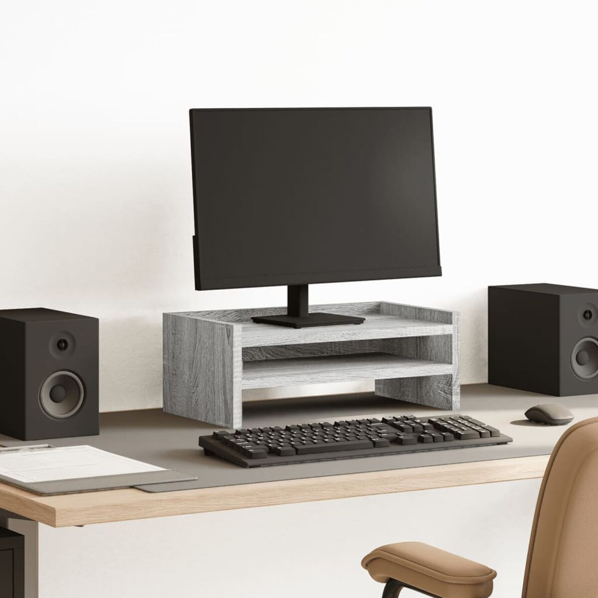 Schreibtisch-Setup mit Monitor, Lautsprechern, Tastatur und Maus. Hintergrund ist eine Wand.