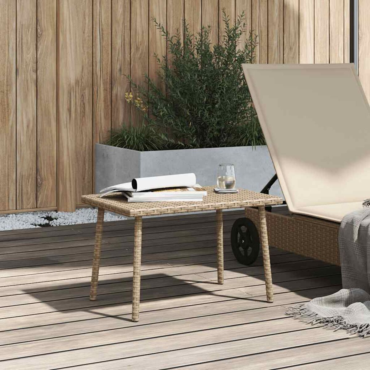 Korbtisch, Bücher, Glas und Liegestuhl im Hintergrund, Outdoor-Setting.