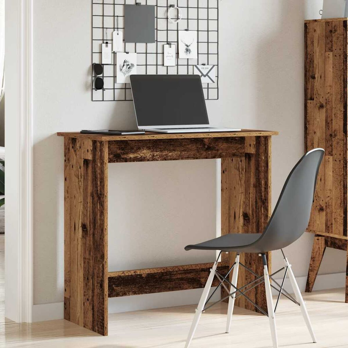 Holzschreibtisch mit Laptop und Stuhl. Ein Raster aus Notizen und Sonnenbrillen hinter dem Schreibtisch.