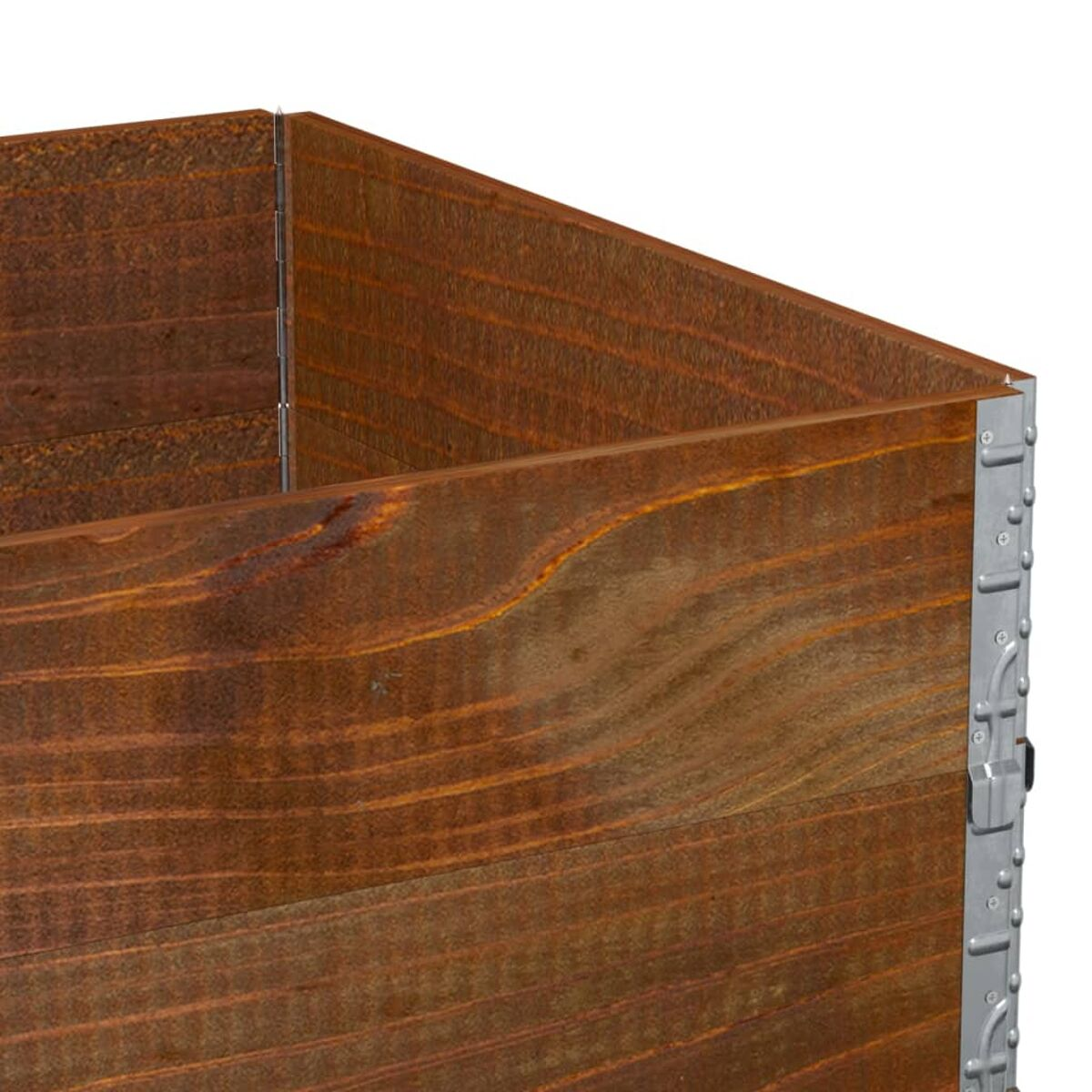 Primo piano dell'angolo di una scatola di legno con strisce metalliche e texture del legno visibili.