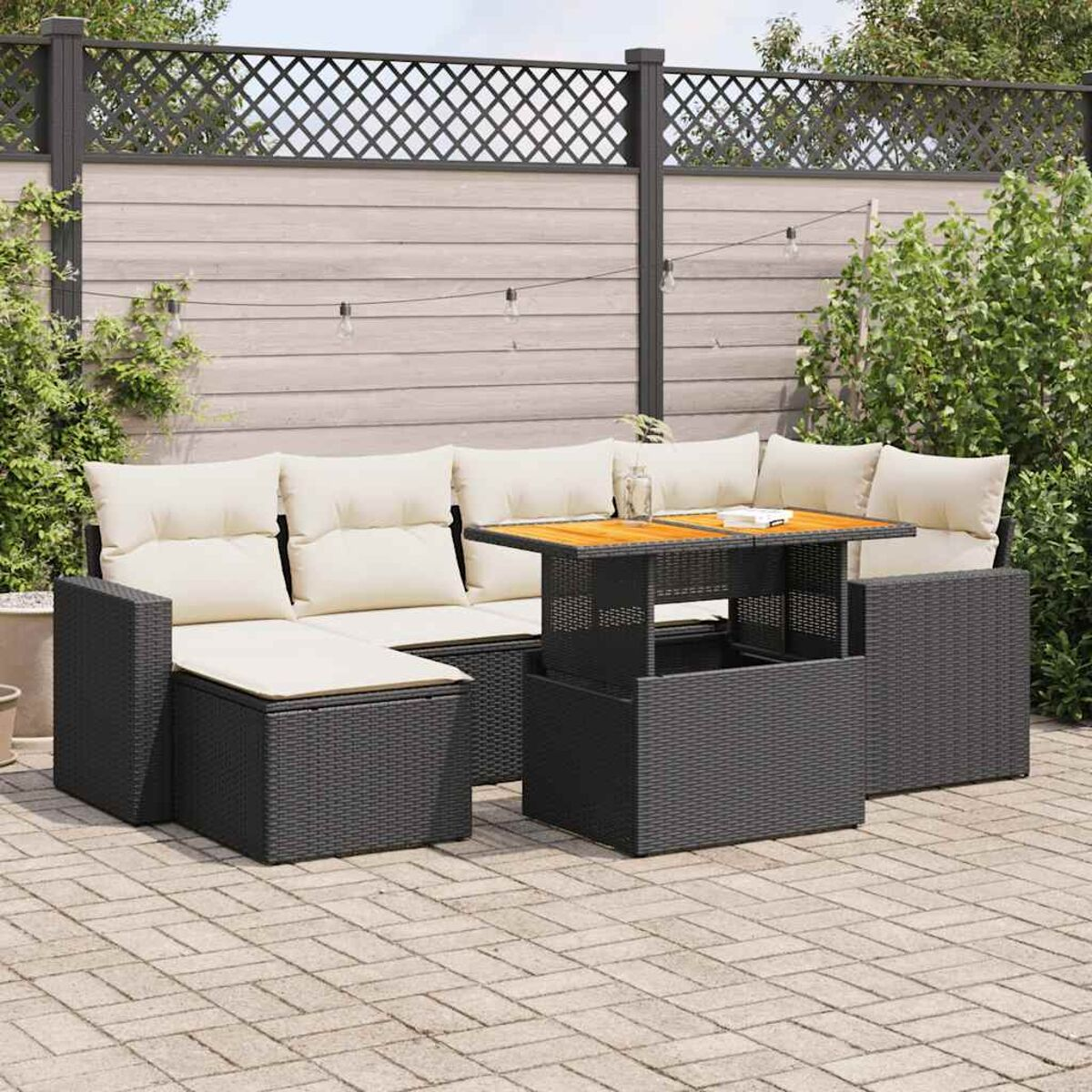 Set divano in rattan nero con tavolo. Il set è su un patio.