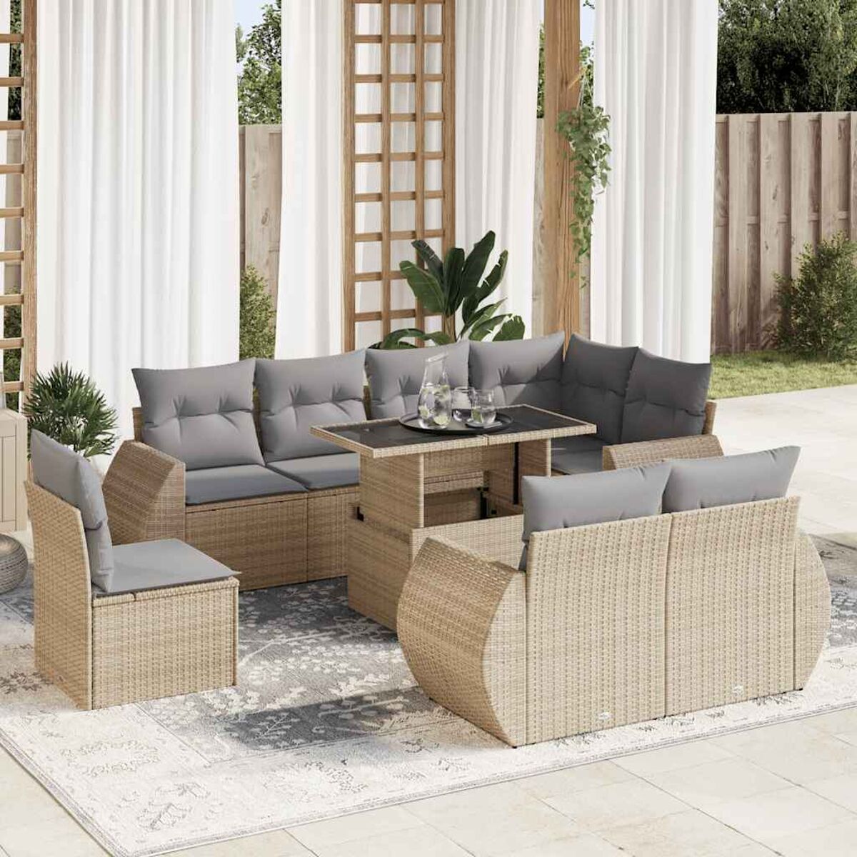 Set di mobili da patio in vimini. Divano componibile, sedie e tavolo elevabile su un tappeto.