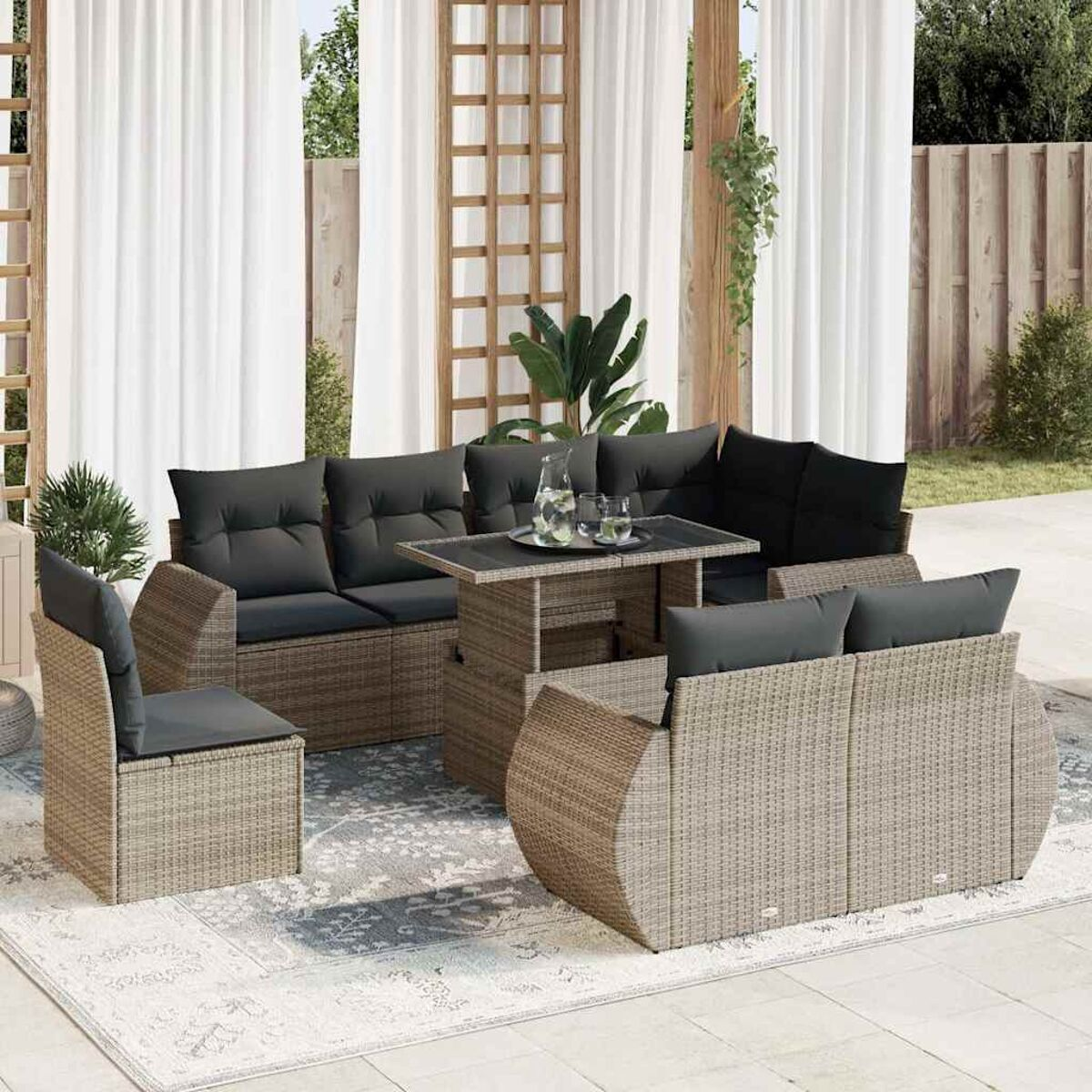 Set di mobili da patio: divano, sedia e tavolo. Tende e tappeto sullo sfondo.