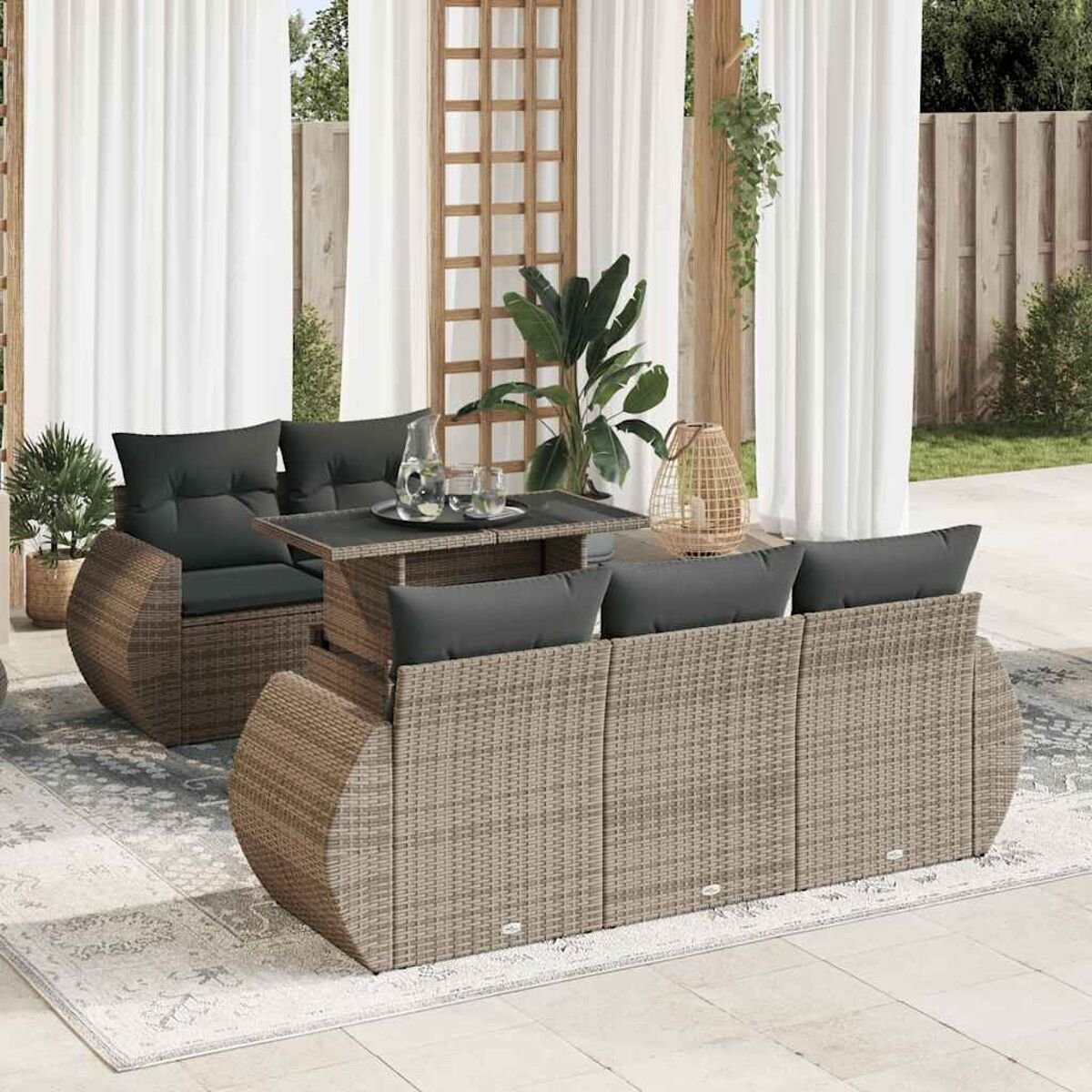 Set di mobili da esterno in vimini. Include divano, tavolo e sedia. Scena su un patio.