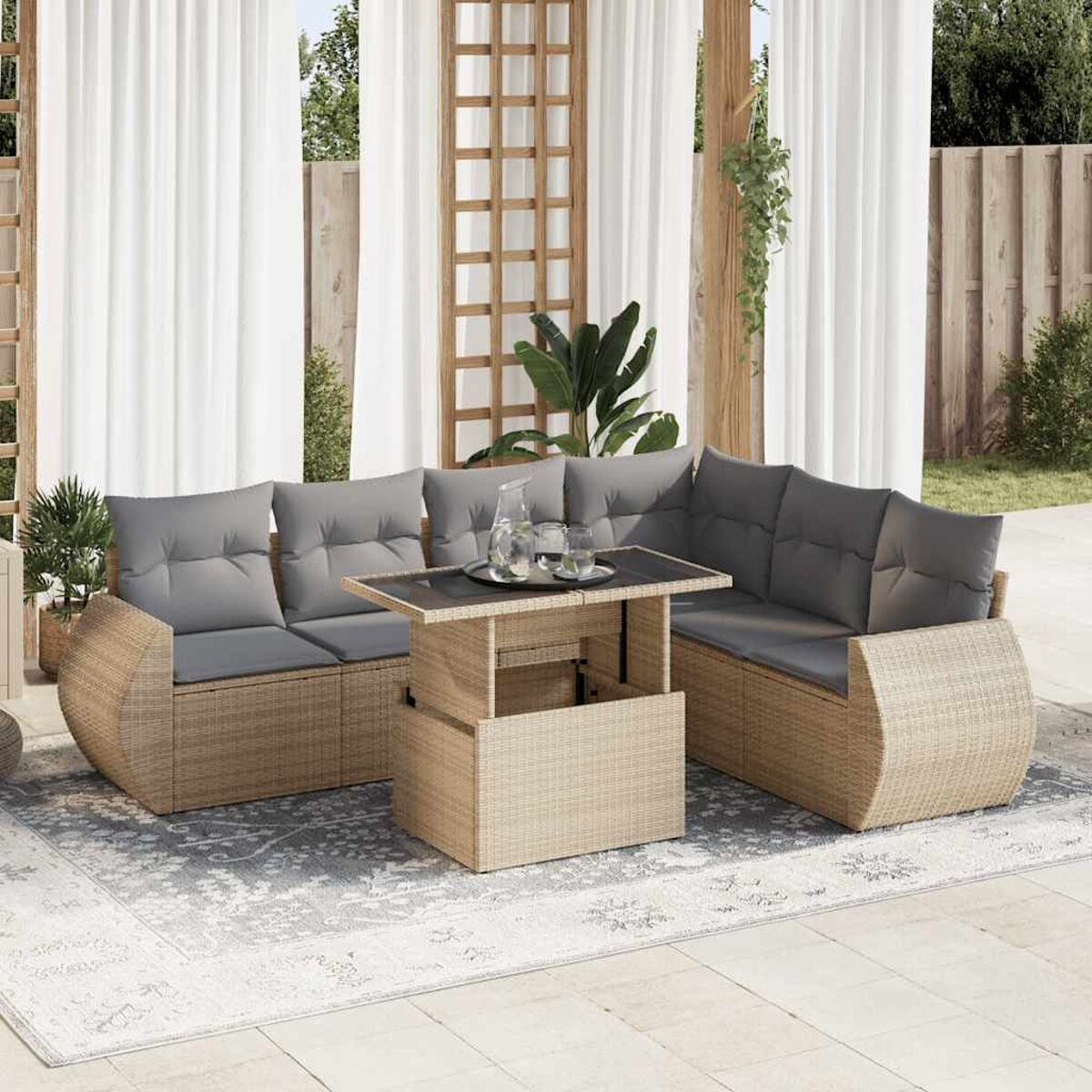 Geflochtenes Outdoor-Möbelset. Graue Kissen. Tisch mit Getränken. Sonniger Tag.