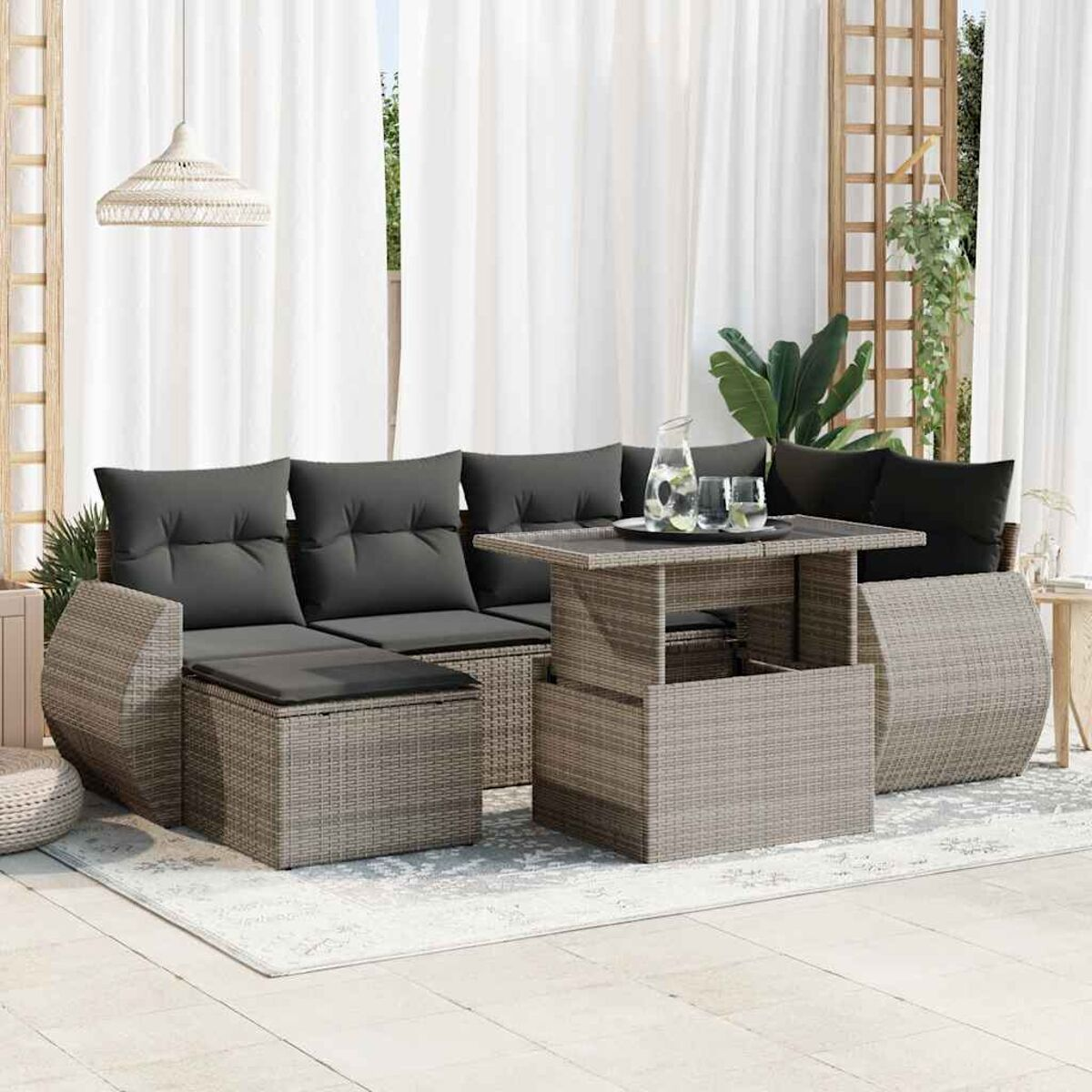 Set da patio esterno con divano, pouf e tavolino con alzata. La scena è ben illuminata.