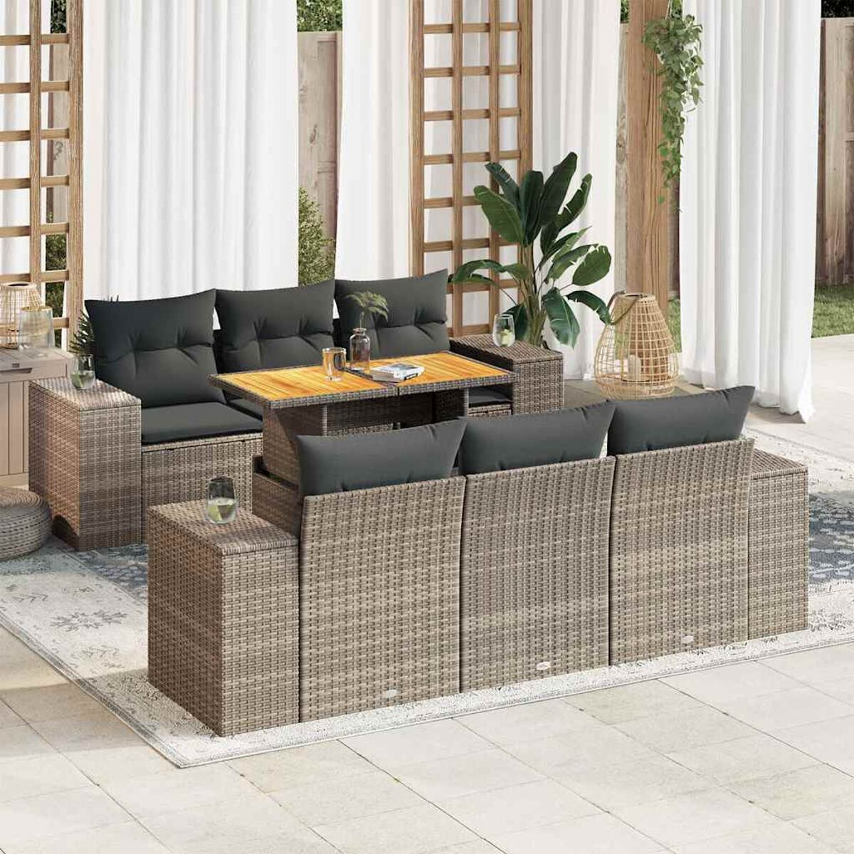 Set da patio con divani, tavolino e elementi decorativi, tutto in toni neutri su un tappeto.