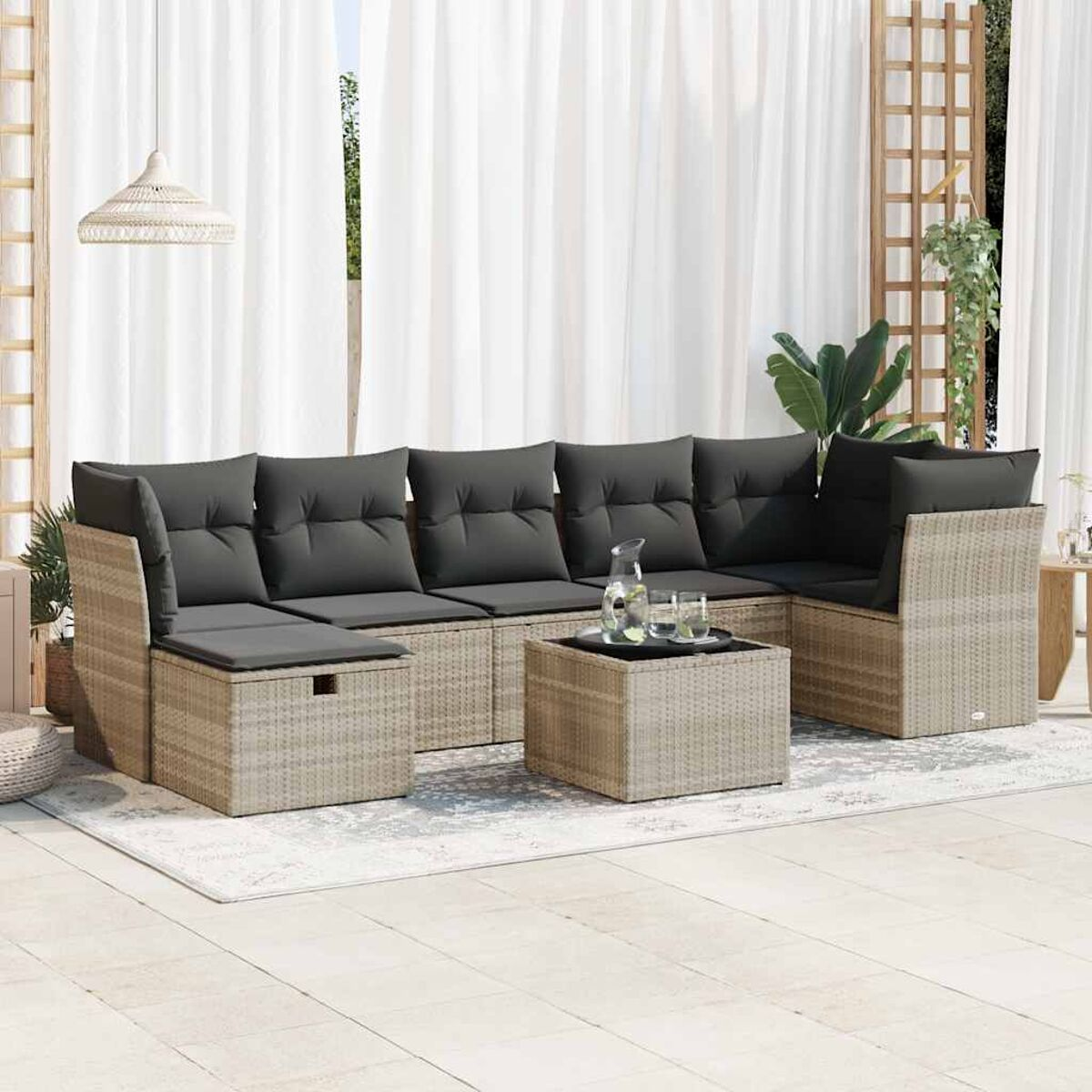 Juego de patio con sofás, mesa de centro y elementos decorativos, todo en tonos neutros sobre una alfombra.