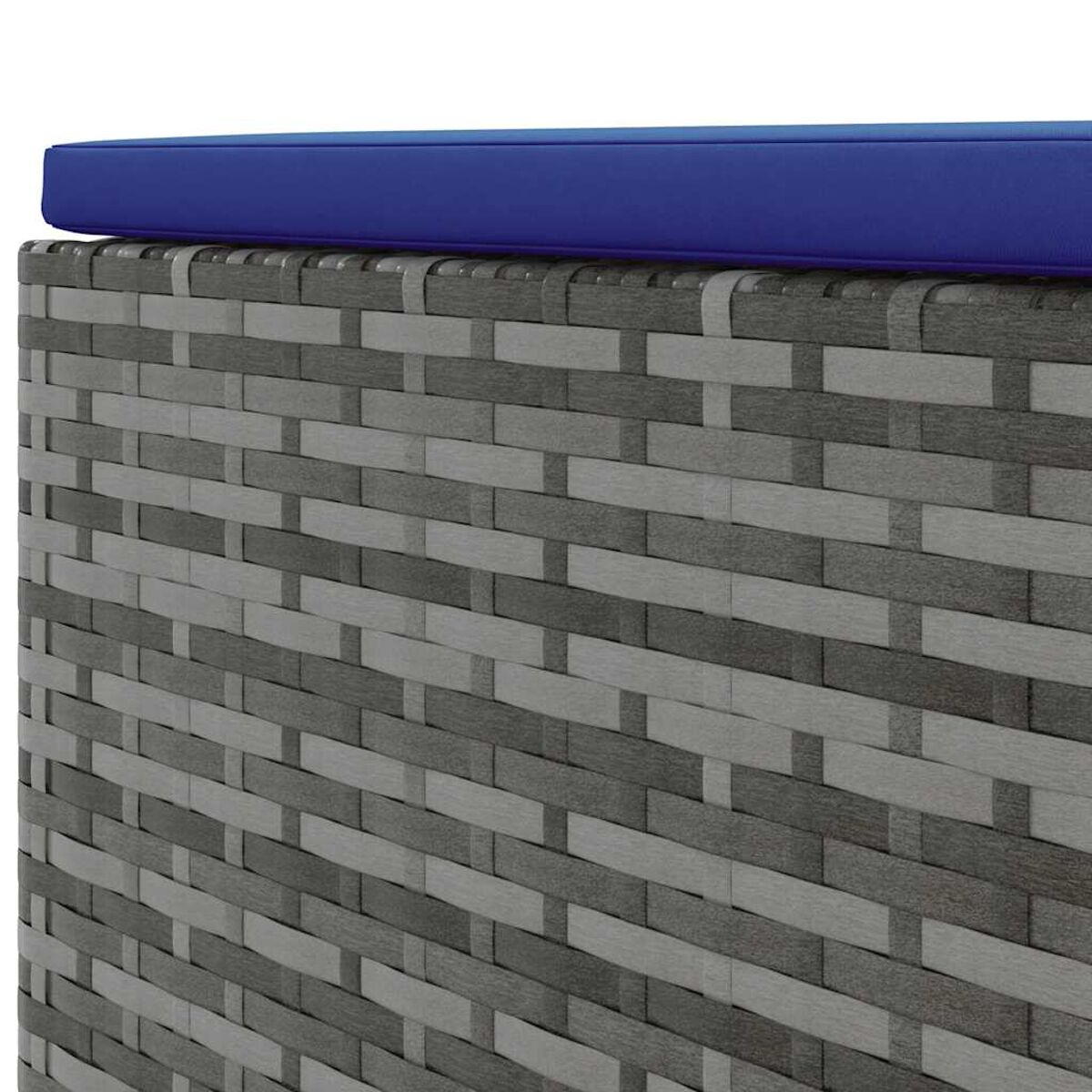 Primo piano di un contenitore in vimini, grigio e bianco. Un cuscino blu sopra. Il vimini è intrecciato.