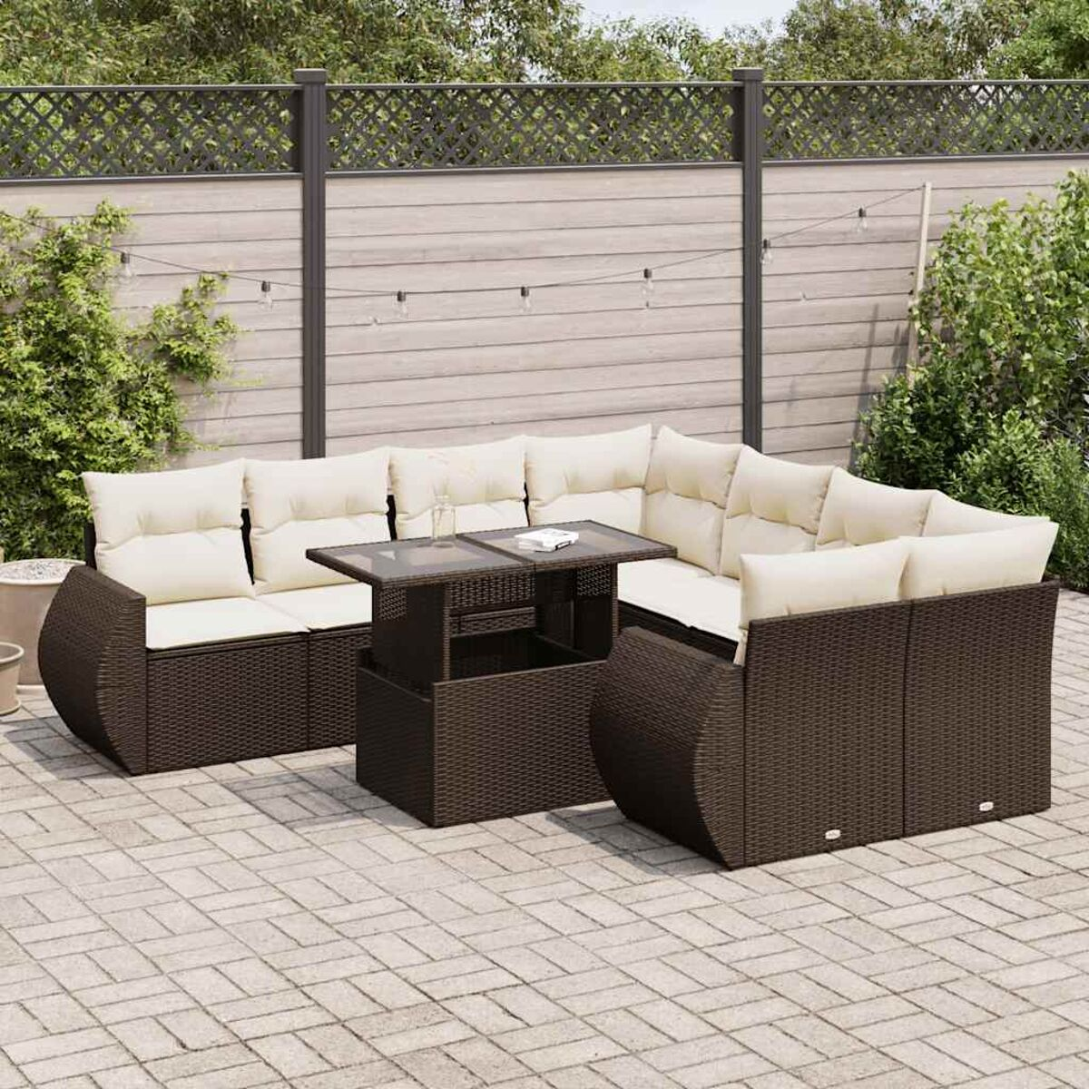 Set di mobili da esterno in vimini marrone scuro. Include un divano componibile e un tavolo su un patio in mattoni.
