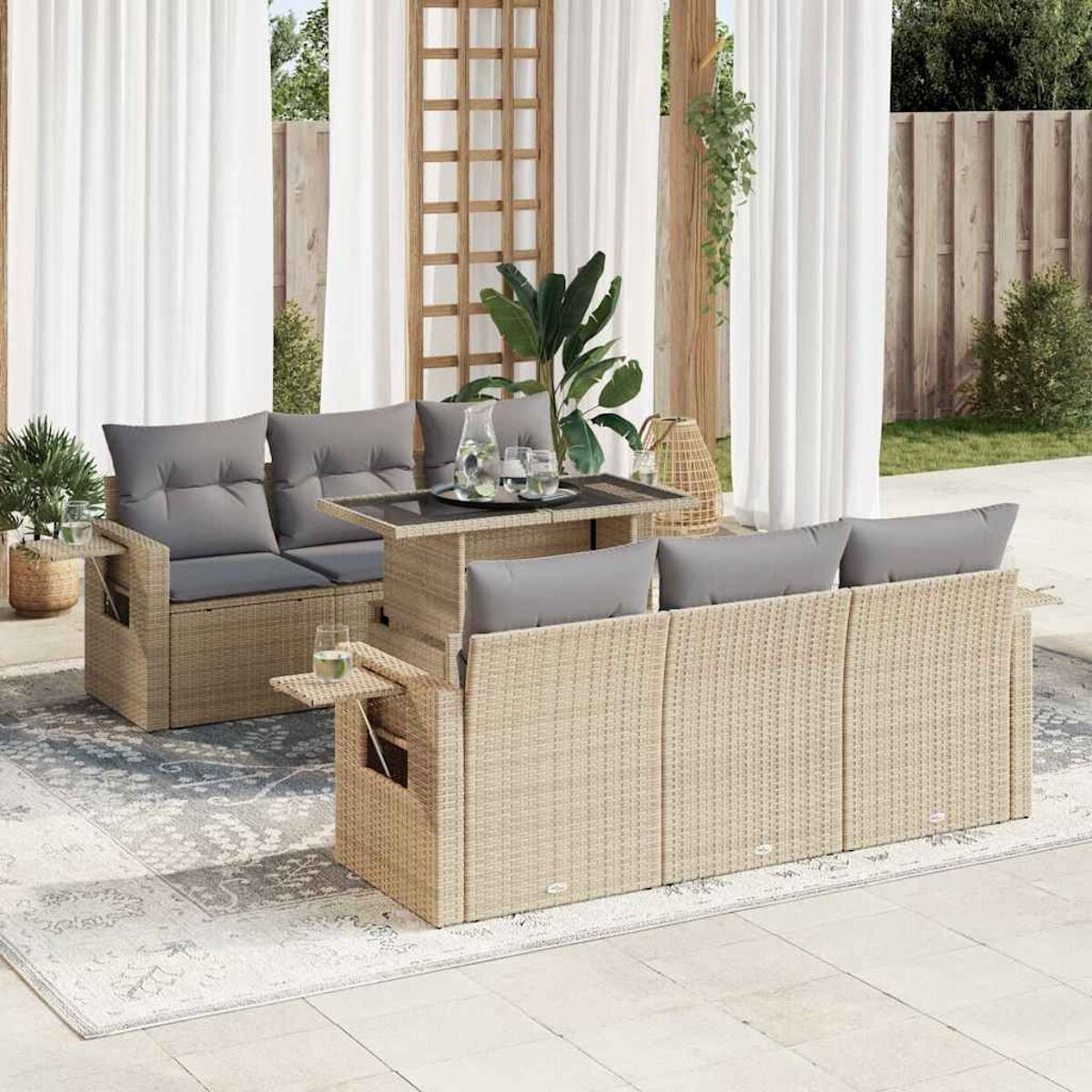Set divano in rattan da esterno con tavolo elevabile, cuscini e tavolini.