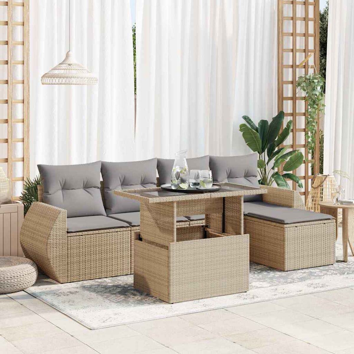 Set divano beige da esterno con tavolo sollevabile su patio piastrellato, tende bianche e pianta rampicante.