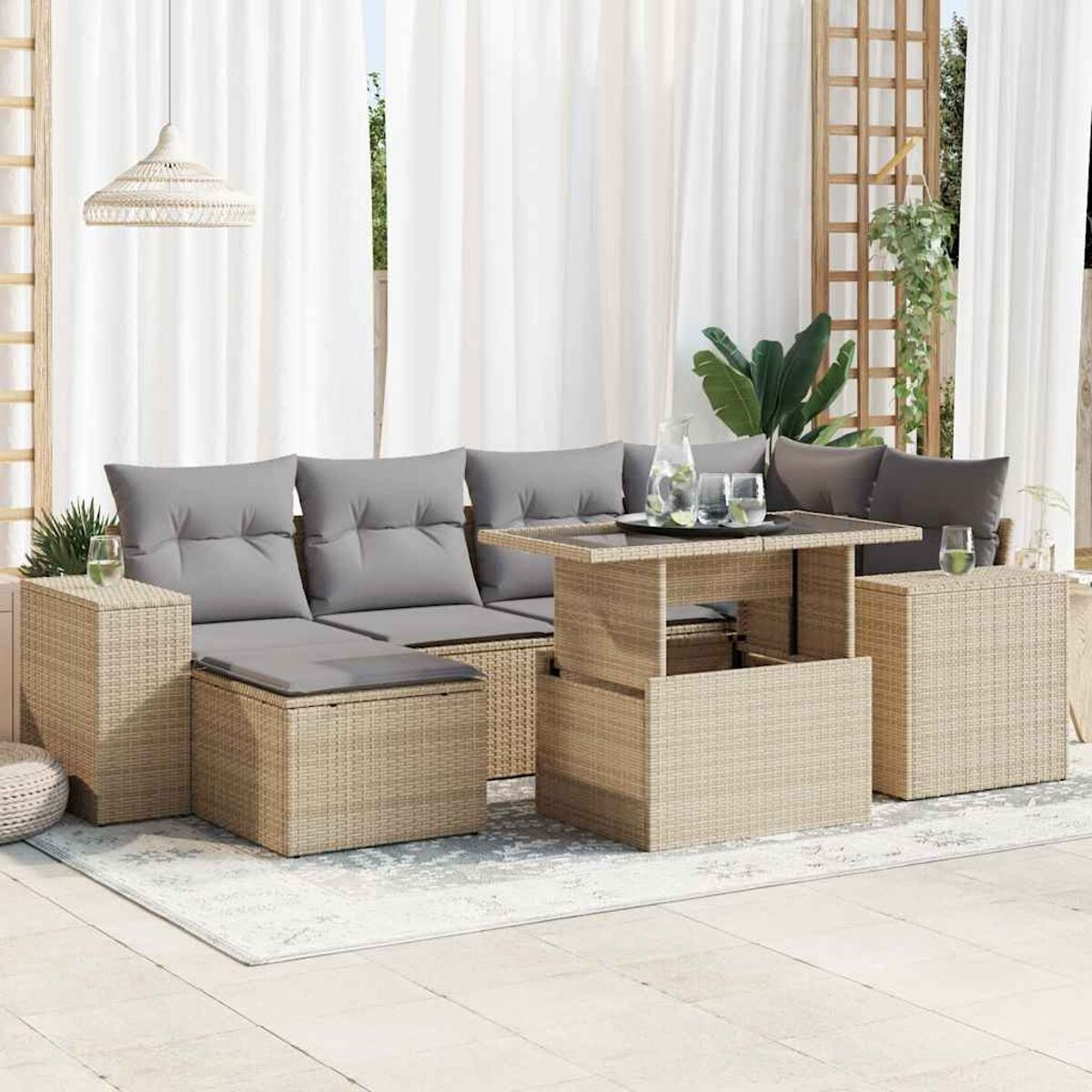 Divano componibile da esterno in rattan con cuscini, tavolo e tende.