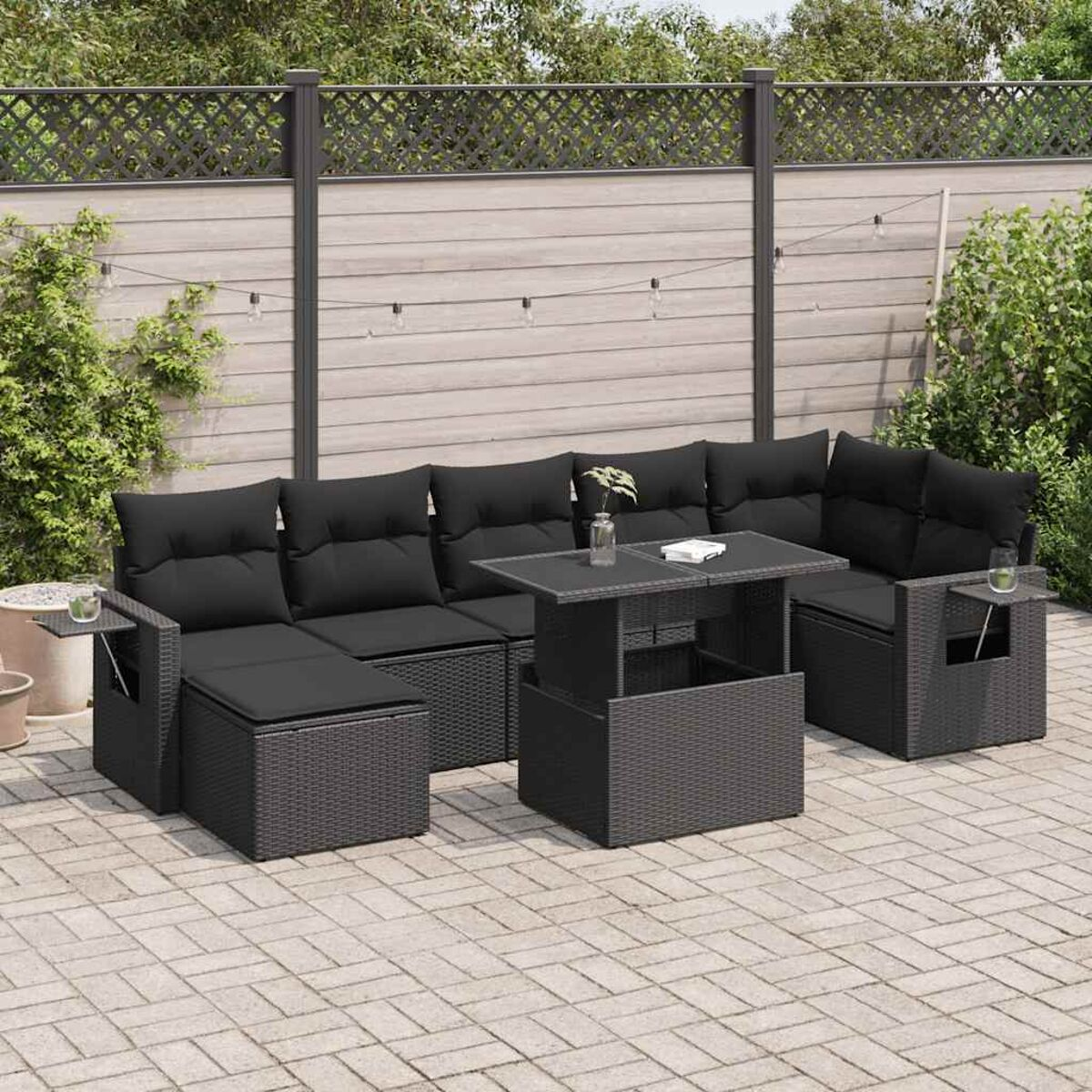 Schwarzes Rattan-Outdoor-Sofa-Set mit Tisch und schwarzen Kissen.