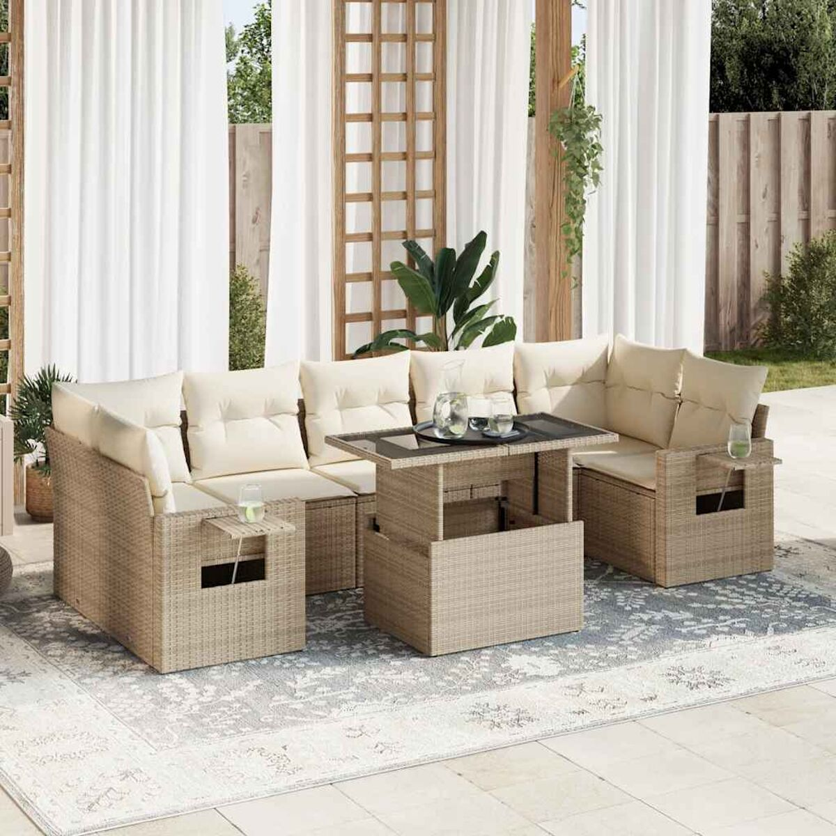 Divano componibile in vimini beige con tavolo elevabile, su un tappeto fantasia e tende.