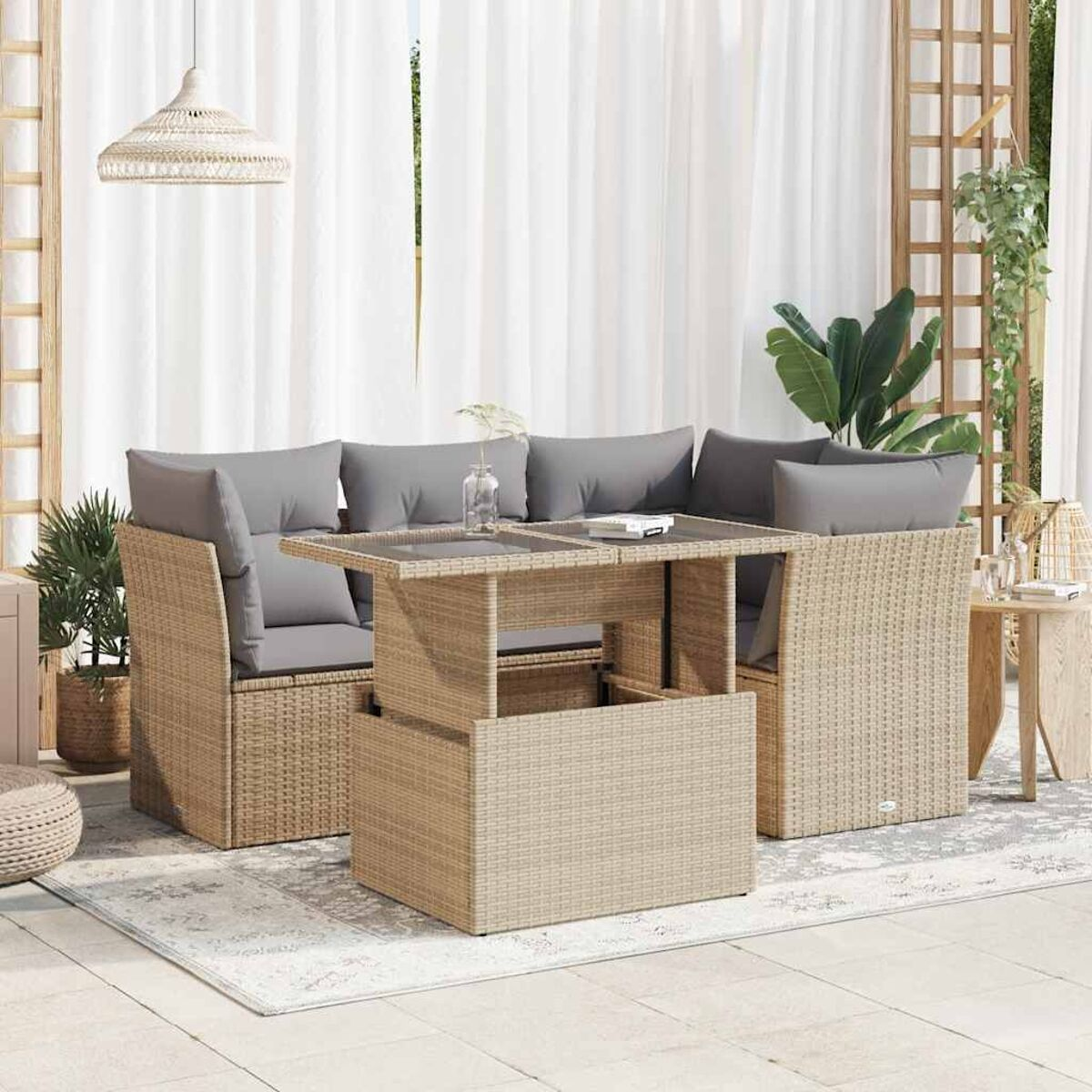 Beiges Rattan-Sofa für den Außenbereich mit grauen Kissen, Tisch und Vorhängen.