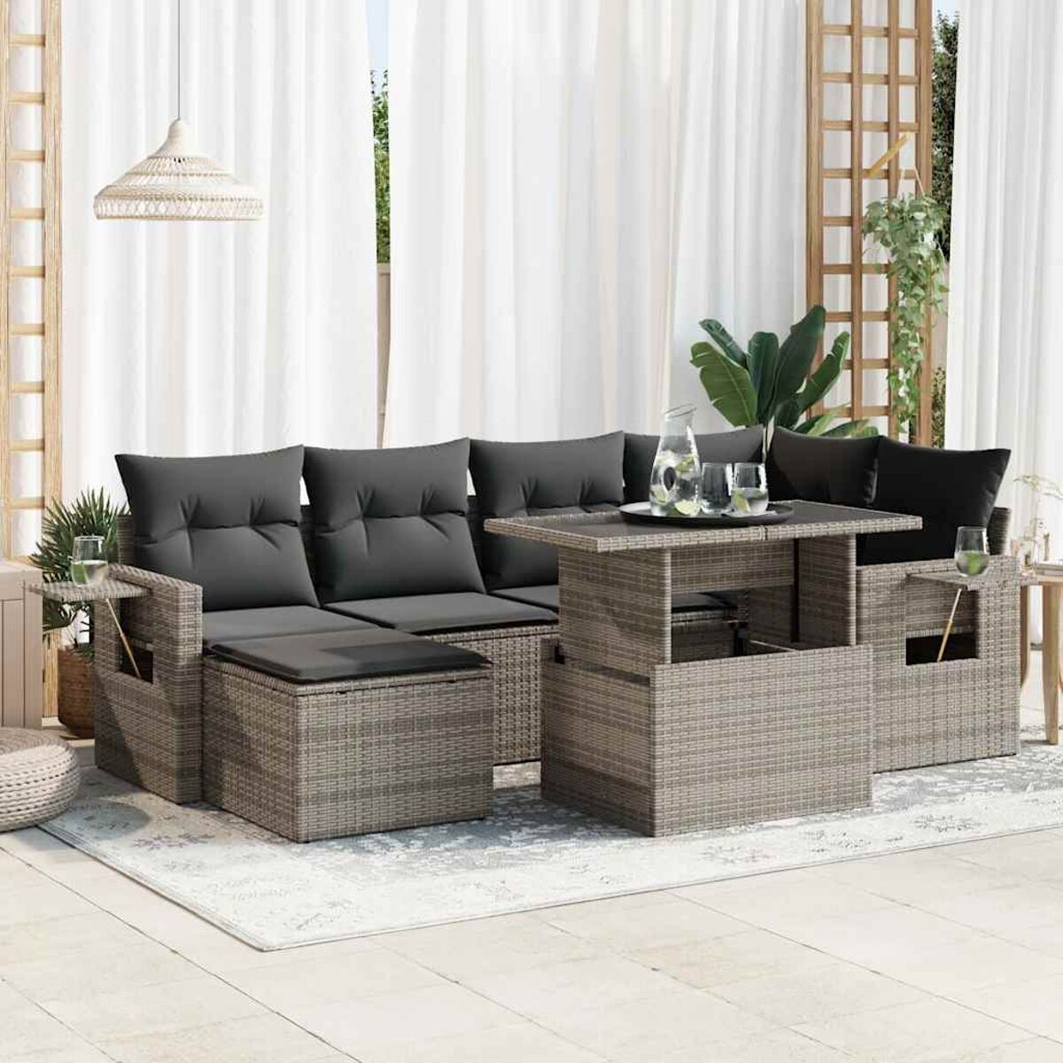 Beiges Outdoor-Korbsesselset mit grauen Kissen und einem Tisch. Weiße Vorhänge im Hintergrund.