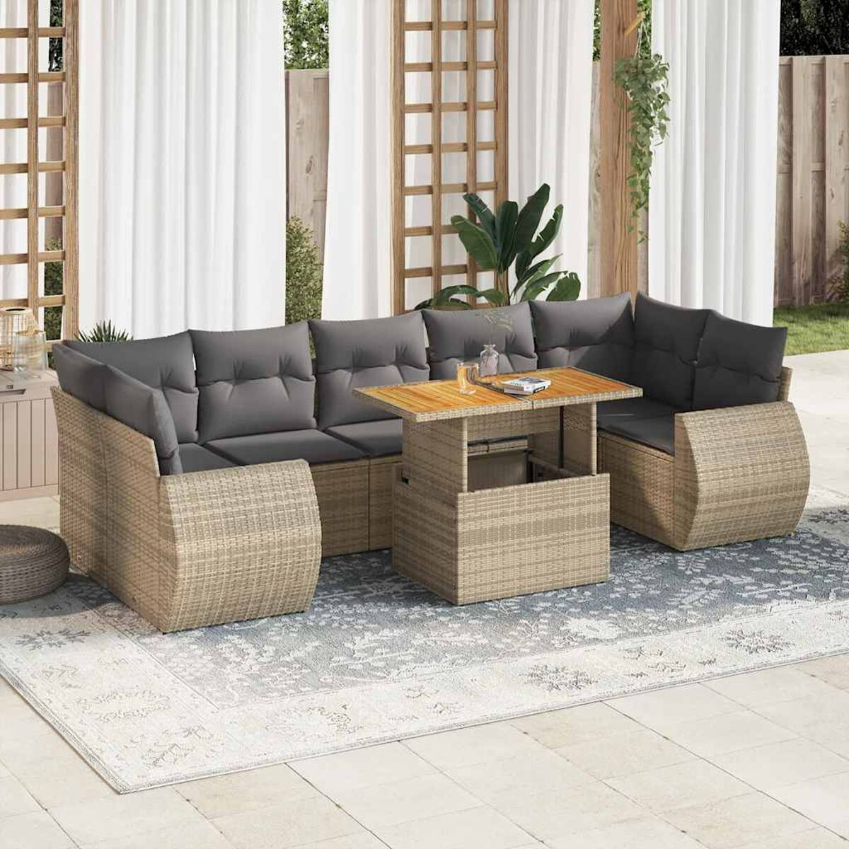 Set da esterno in vimini beige: divano, tavolo e due sedie con cuscini grigi su un patio.