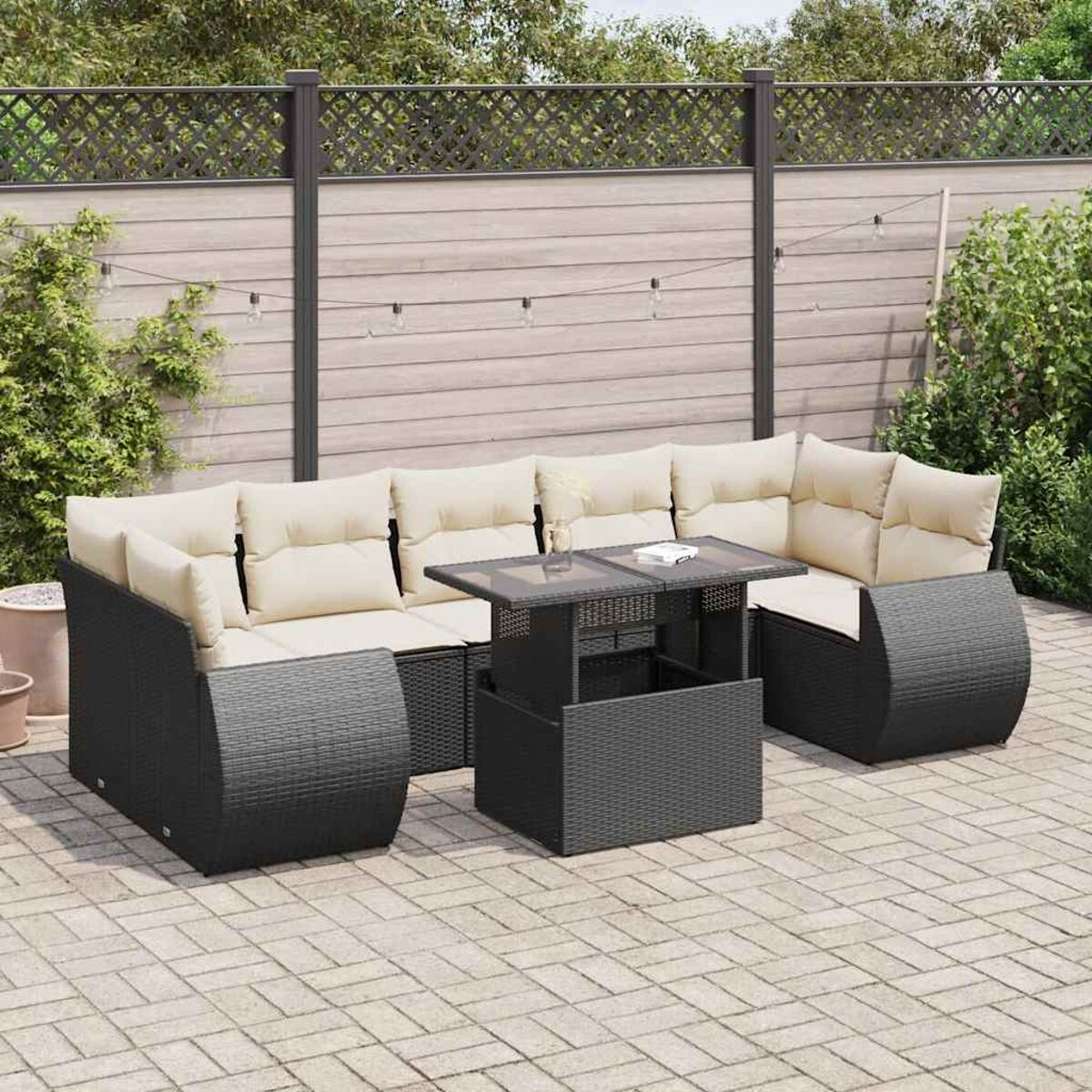 Dunkelgraues Outdoor-Ecksofa mit Tisch auf einer Ziegelterrasse.