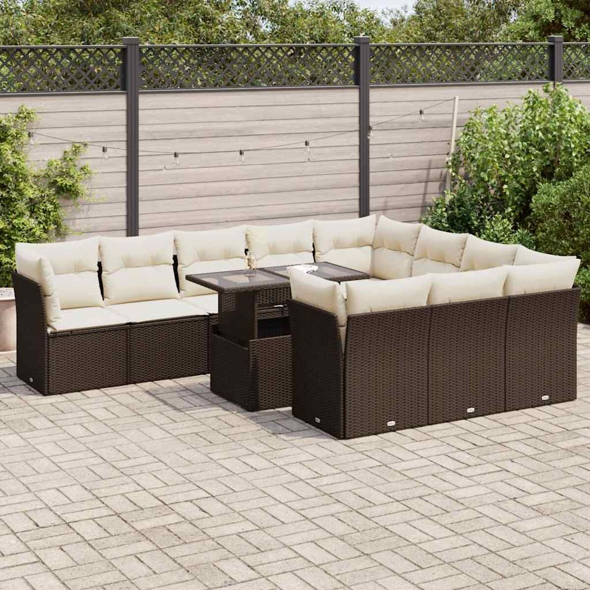 Braunes Korbmöbel-Set für den Außenbereich mit beigen Kissen. Beinhaltet einen Tisch und steht auf einer Terrasse.