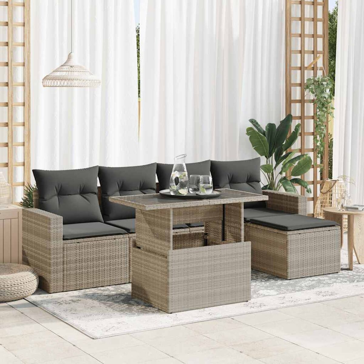 Geflochtenes Outdoor-Möbelset mit Kissen und Tisch, draußen aufgestellt.