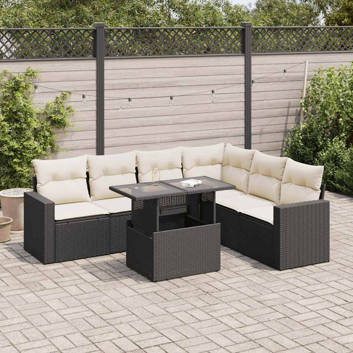Set di mobili da esterno neri con cuscini beige e tavolo sollevabile su un patio.