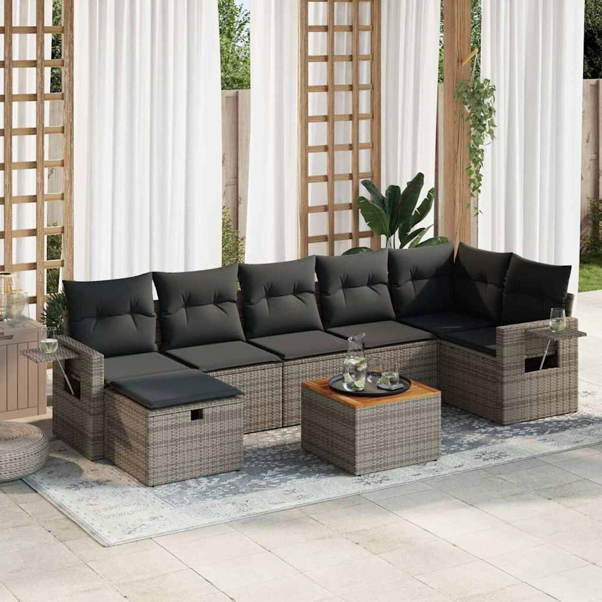 Rattansofa-Set für den Außenbereich mit grauen Kissen und einem Holztisch.