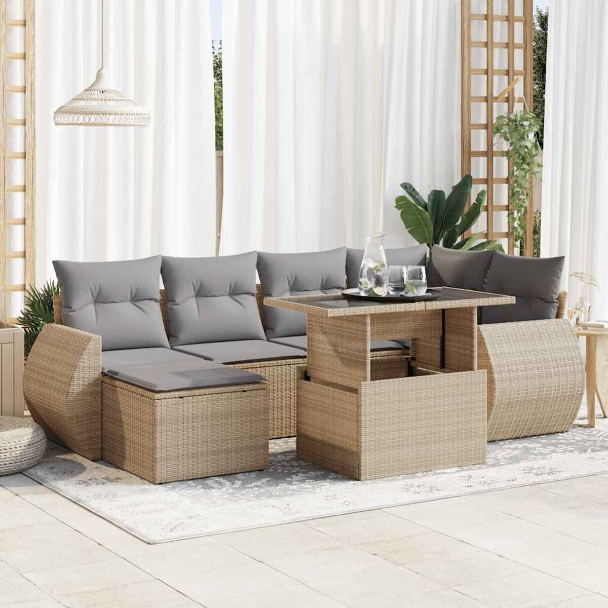 Set di mobili da esterno in rattan con cuscini grigi e un tavolo con piano sollevabile.
